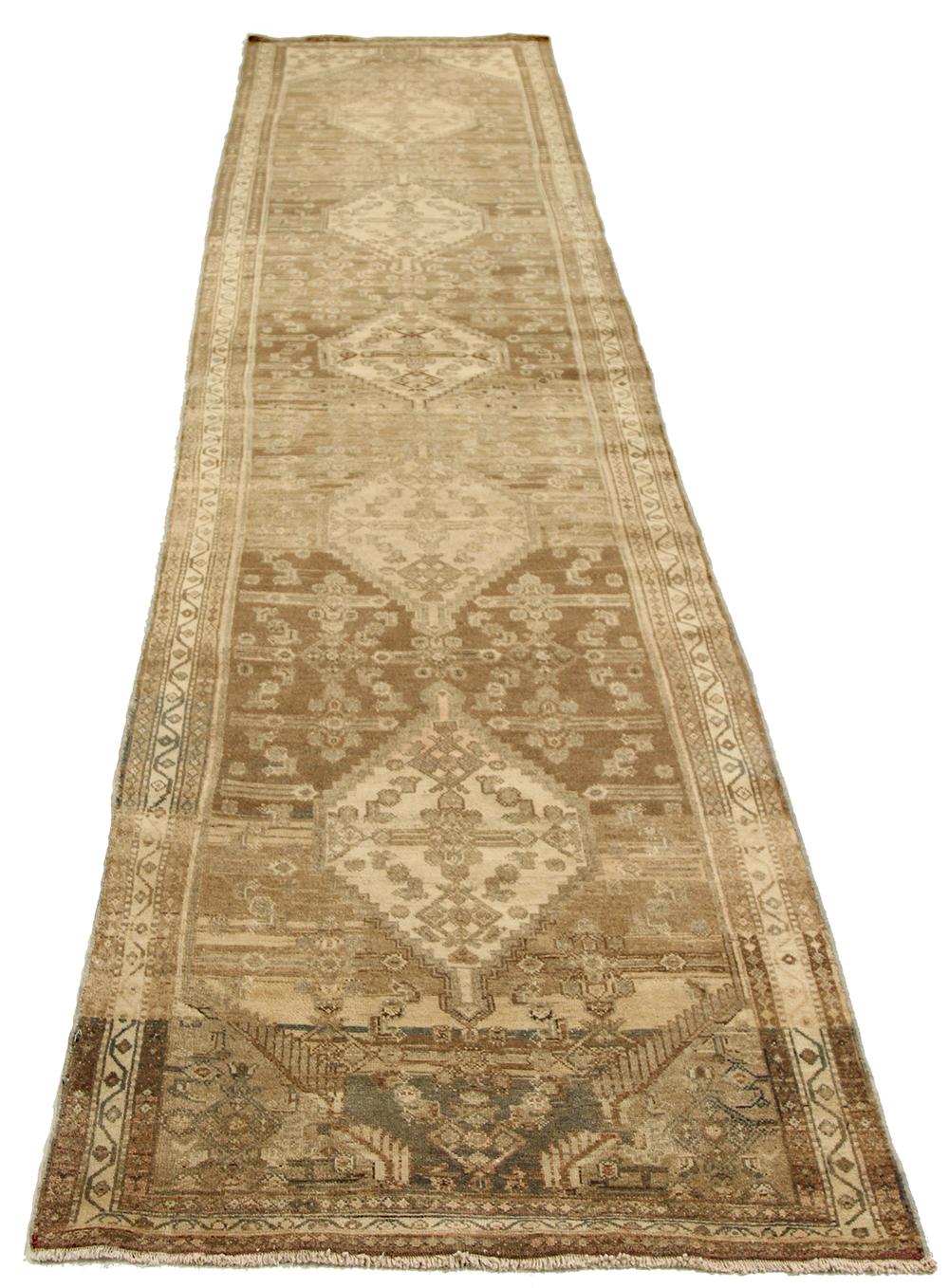 Antique Persian runner rug handwoven from the finest sheep’s wool and colored with all-natural vegetable dyes that are safe for humans and pets. It’s a traditional Malayer design featuring brown and beige botanical patterns over an ivory field. It’s