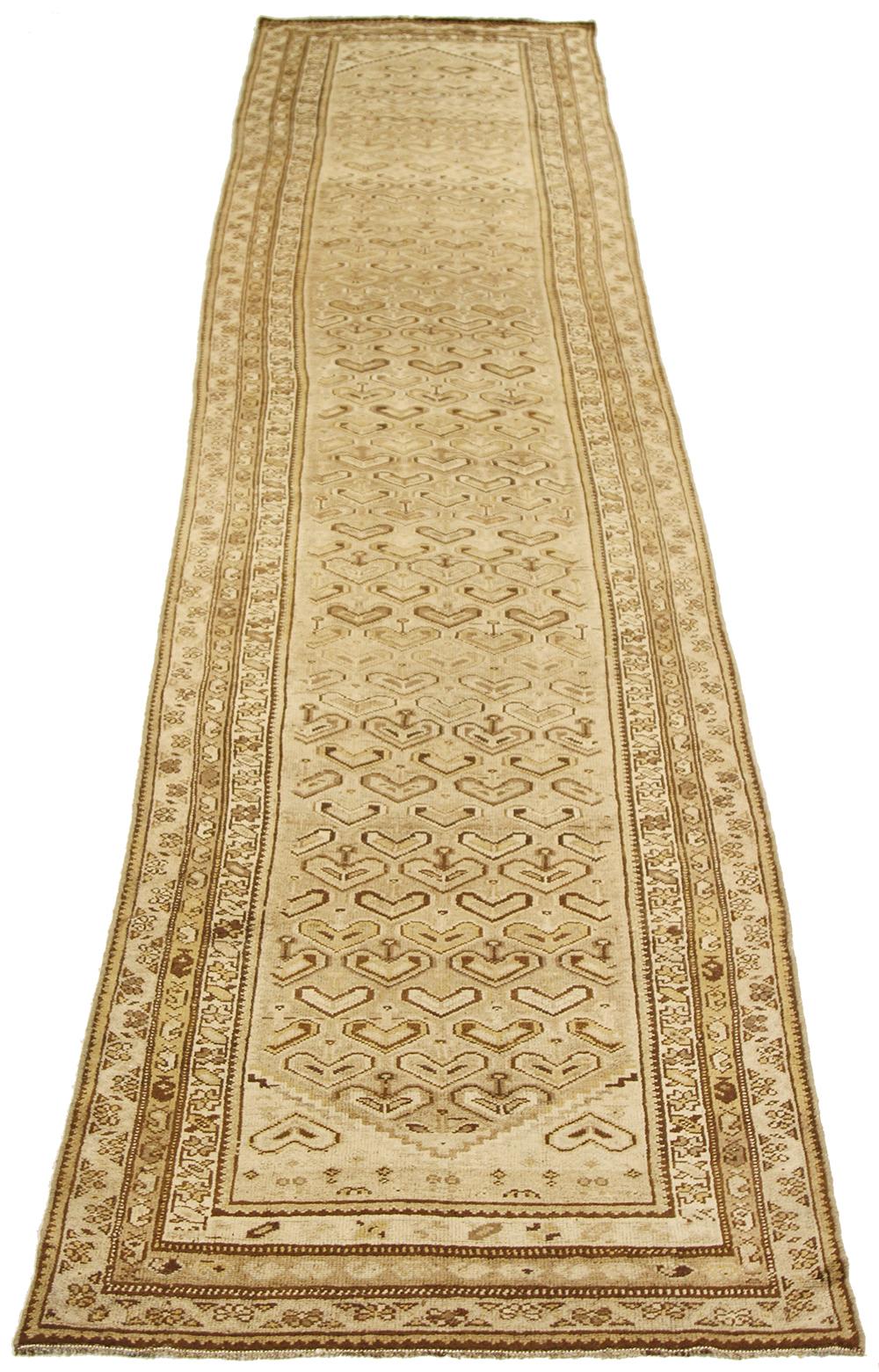 Antique Persian runner rug handwoven from the finest sheep’s wool and colored with all-natural vegetable dyes that are safe for humans and pets. It’s a traditional Malayer design featuring brown and beige heart-shaped details on an ivory field. It’s