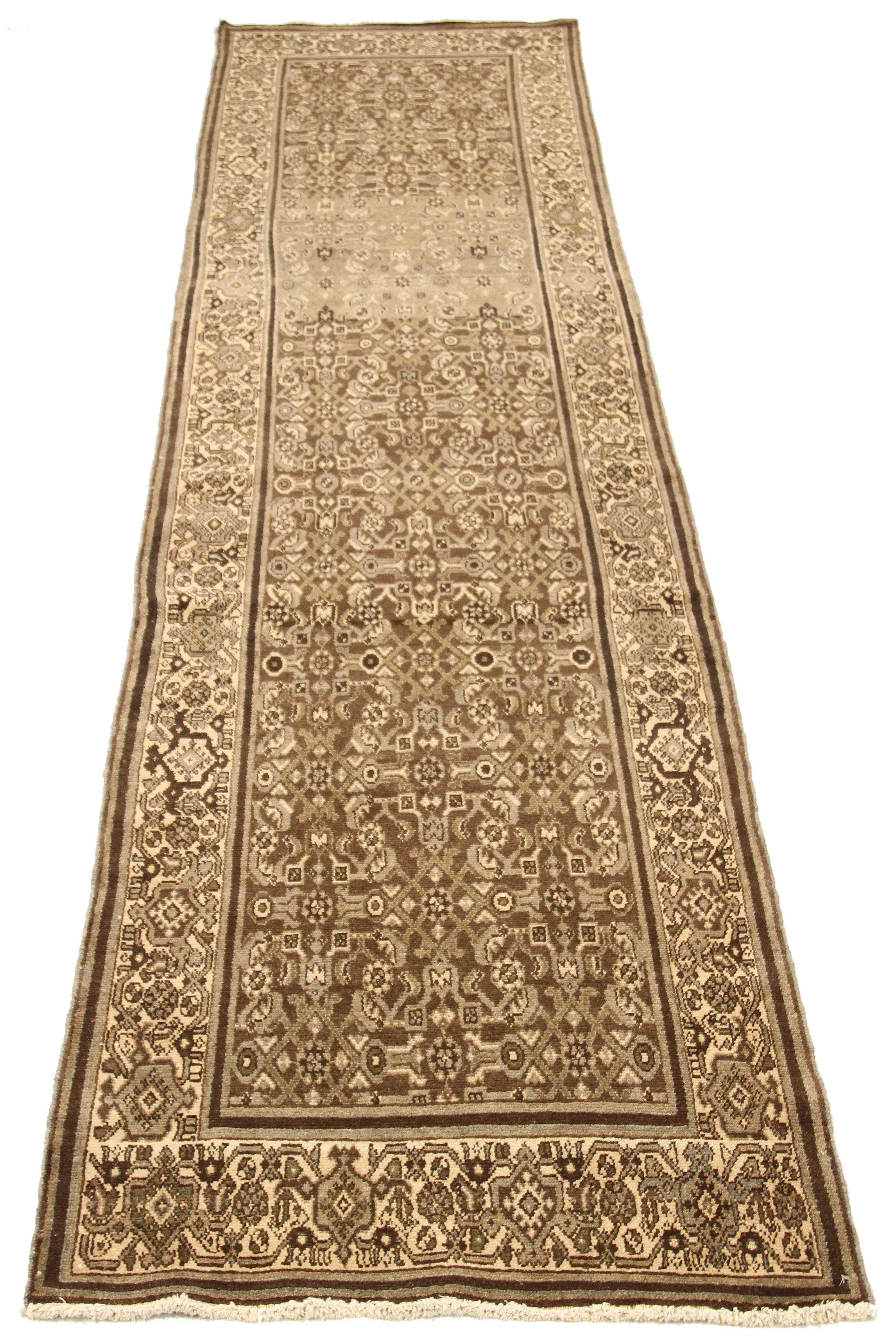 Antique Persian runner rug handwoven from the finest sheep’s wool and colored with all-natural vegetable dyes that are safe for humans and pets. It’s a traditional Malayer design featuring brown geometric patterns over an ivory field. It’s a lovely