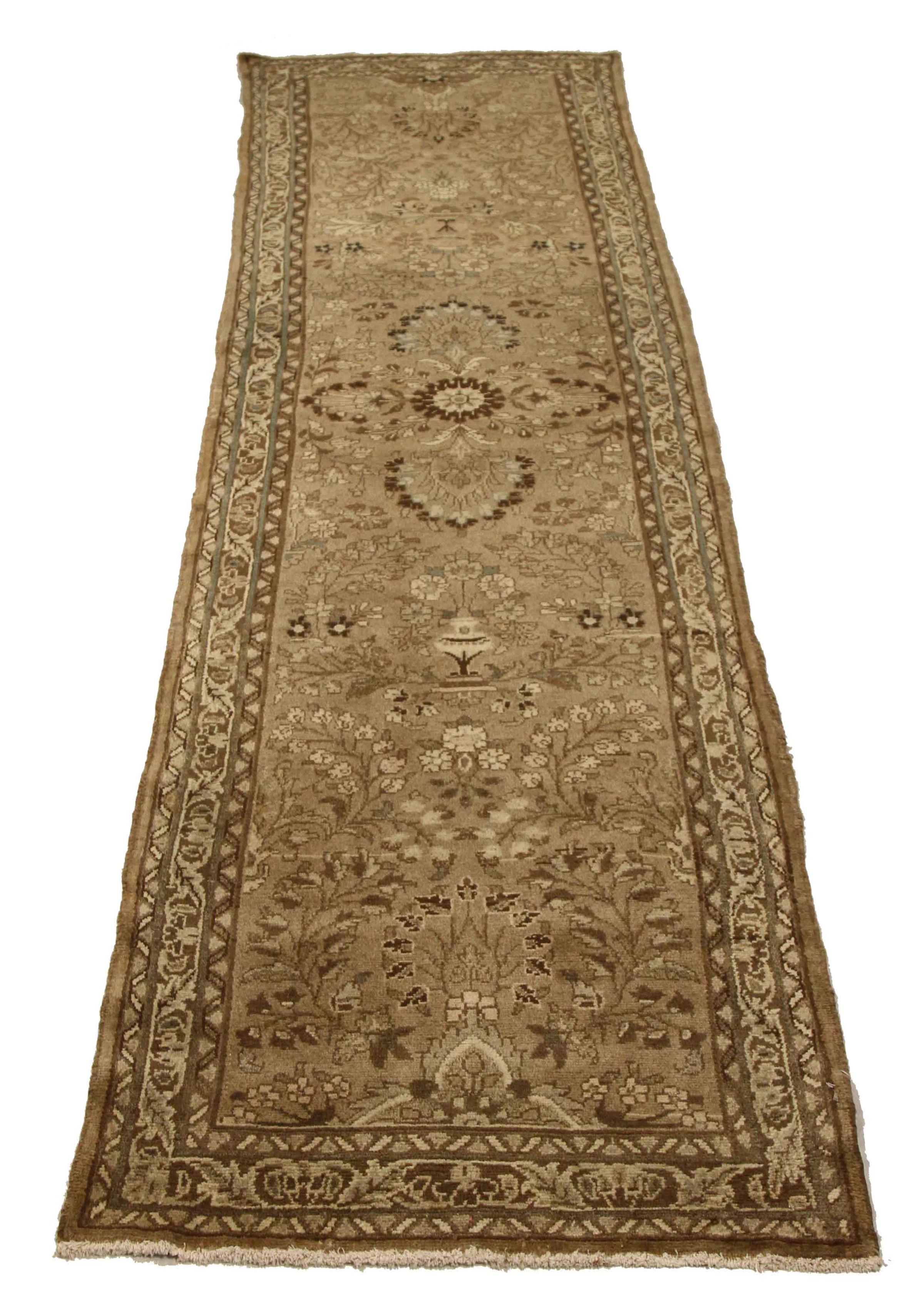 Antique Persian runner rug handwoven from the finest sheep’s wool. It’s colored with all-natural vegetable dyes that are safe for humans and pets. It’s a traditional Malayer design featuring ivory and brown floral details on a beige field. It’s a