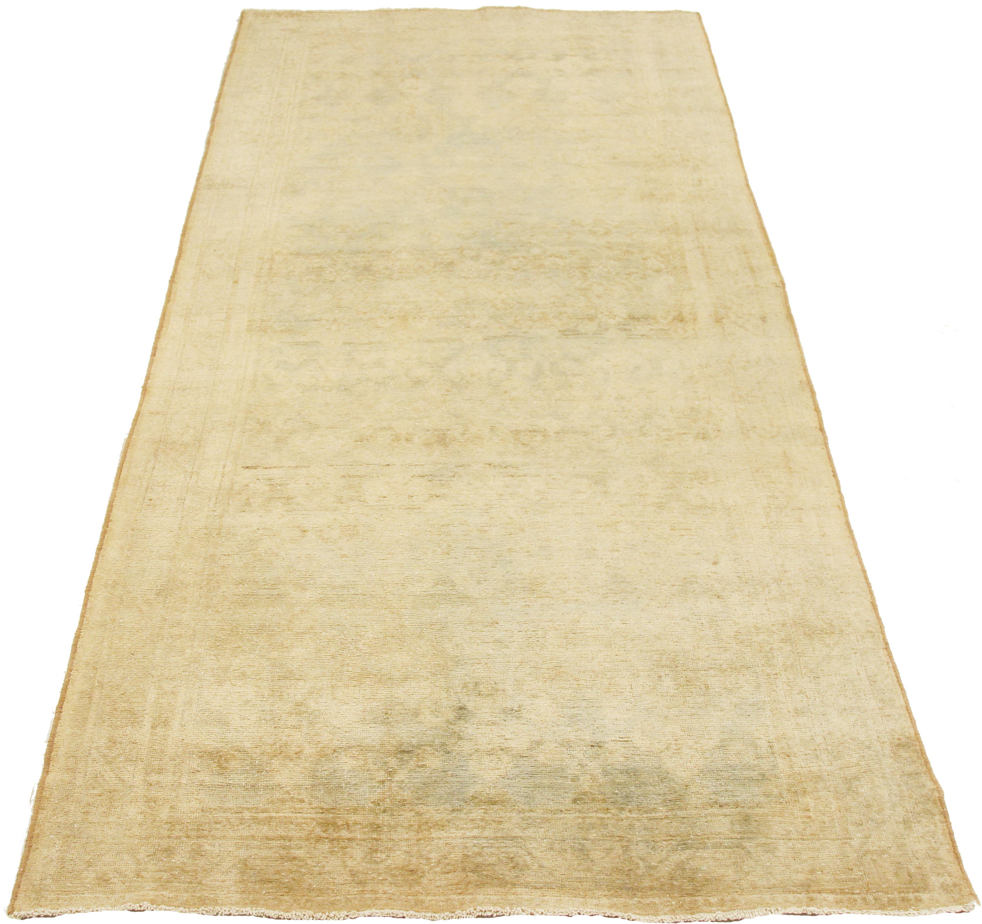 Antique Persian runner rug handwoven from the finest sheep’s wool and colored with all-natural vegetable dyes that are safe for humans and pets. It’s a traditional Malayer design featuring faded beige and green floral details over an ivory field.