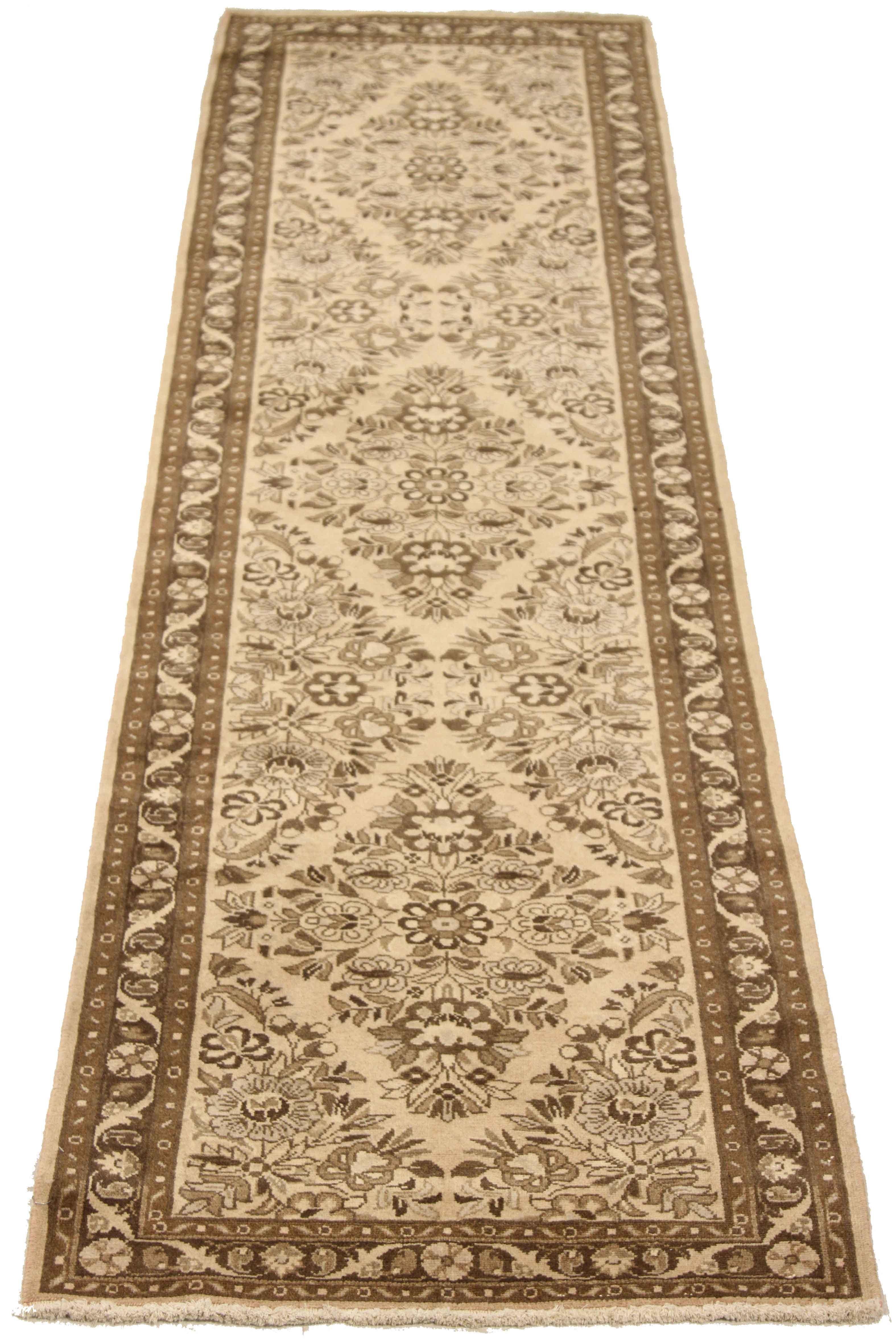 Antique Persian runner rug handwoven from the finest sheep’s wool. It’s colored with all-natural vegetable dyes that are safe for humans and pets. It’s a traditional Malayer design featuring ivory and brown floral details on a beige field. It’s a