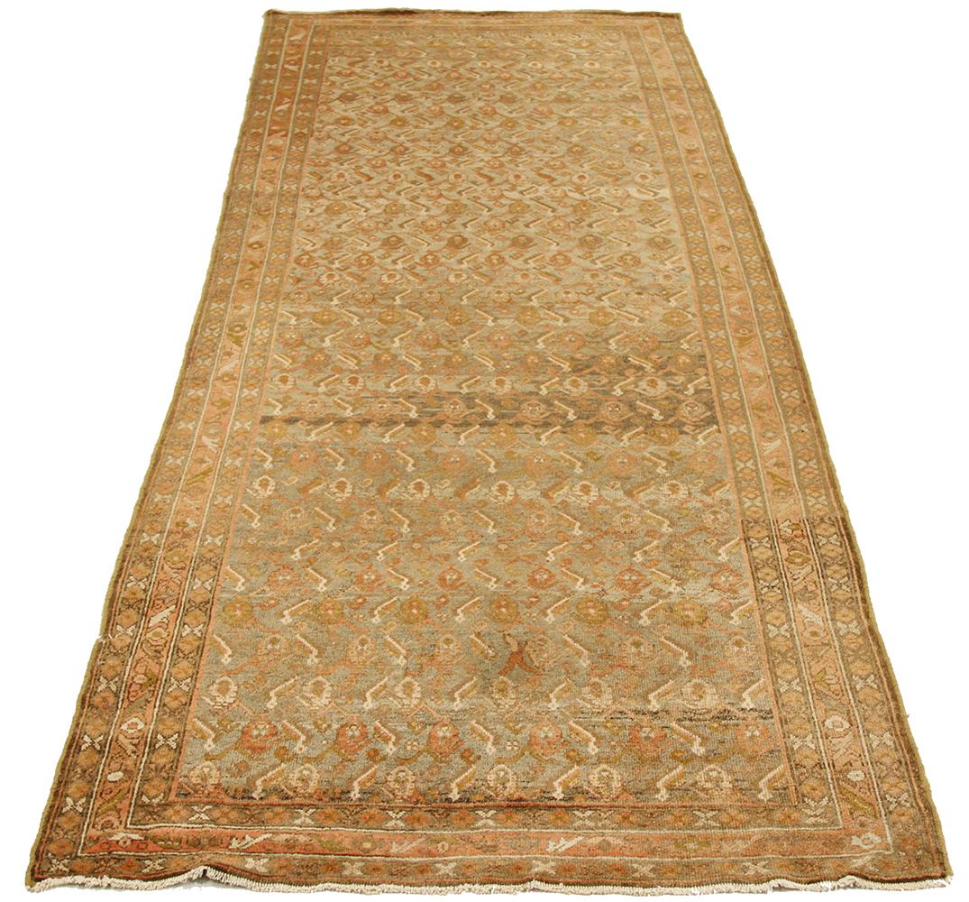Antique Persian runner rug handwoven from the finest sheep’s wool and colored with all-natural vegetable dyes that are safe for humans and pets. It’s a traditional Malayer design featuring pink and green flower heads all over. It’s a lovely piece to