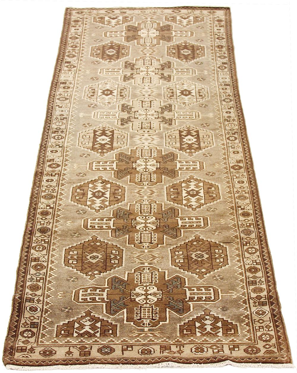 Antique Persian runner rug handwoven from the finest sheep’s wool and colored with all-natural vegetable dyes that are safe for humans and pets. It’s a traditional Malayer design featuring ivory and brown tribal details on a beige field. It’s a