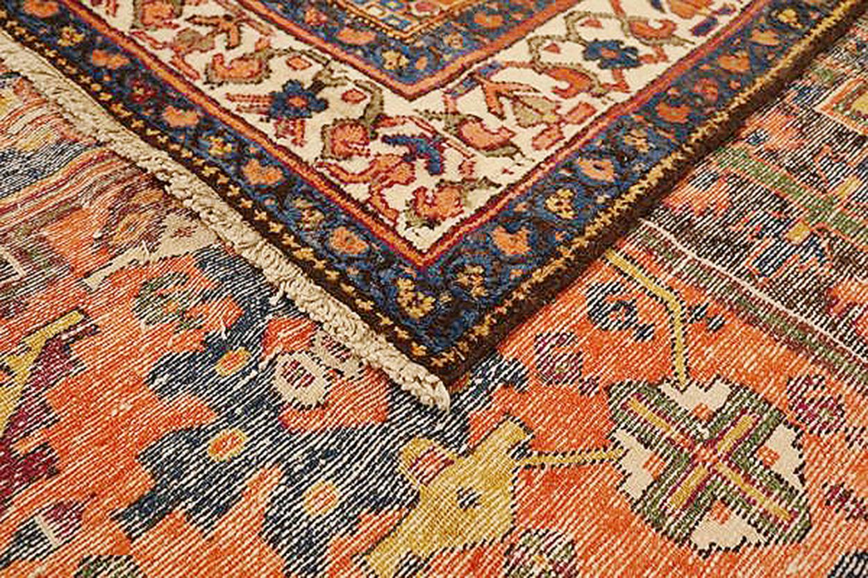 Antique Persian rug handwoven from the finest sheep’s wool and colored with all-natural vegetable dyes that are safe for humans and pets. It’s a traditional Malayer design featuring navy blue, orange and beige central medallions details over a brown