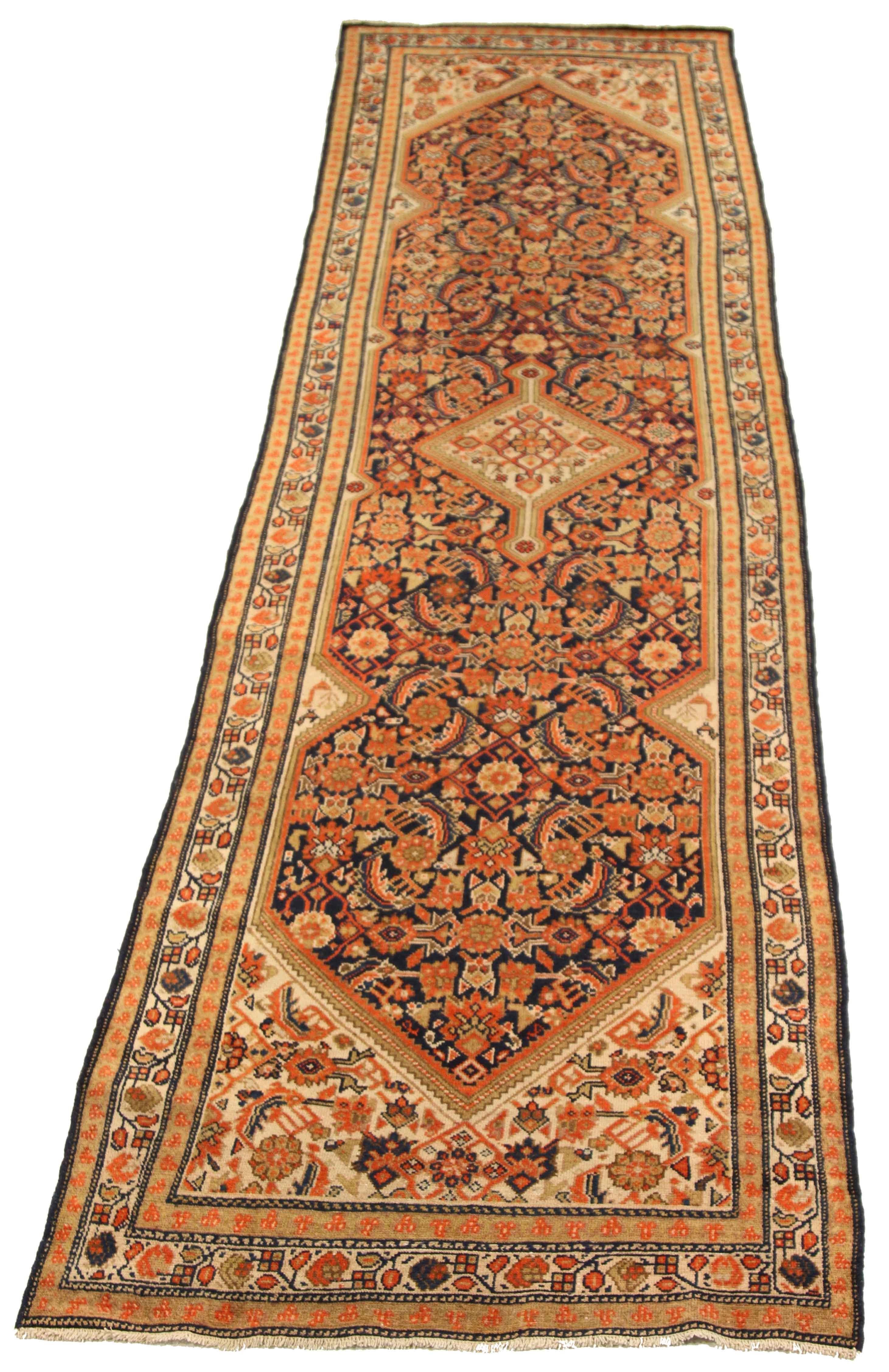 Antique Persian runner rug handwoven from the finest sheep’s wool and colored with all-natural vegetable dyes that are safe for humans and pets. It’s a traditional Malayer design featuring floral details in navy blue and orange over an ivory center