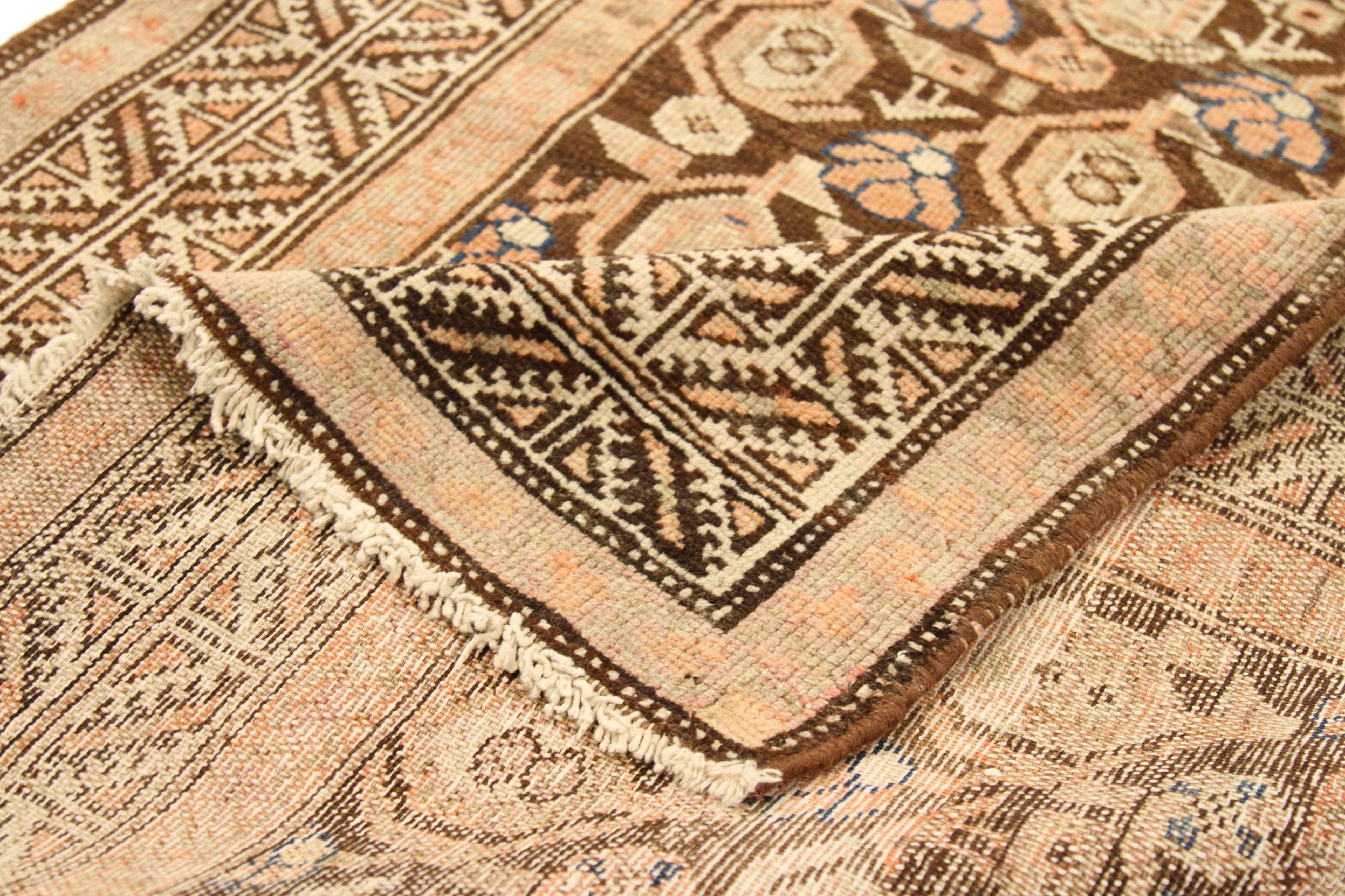 Antique Persian runner rug handwoven from the finest sheep’s wool and colored with all-natural vegetable dyes that are safe for humans and pets. It’s a traditional Malayer design featuring ‘Boteh’ details in pink and beige over a brown center field.