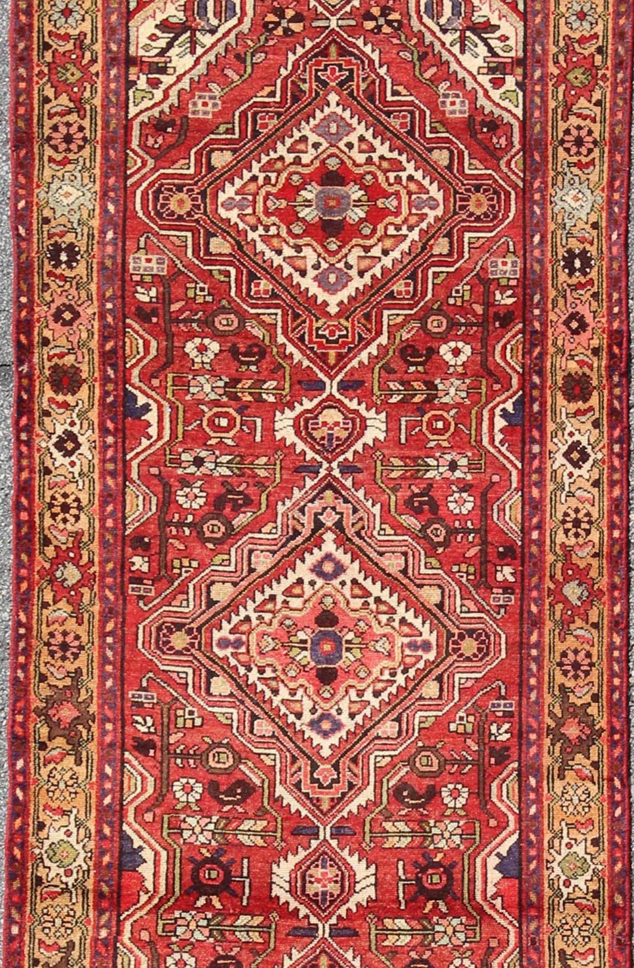 Sub-geometric floral design antique Malayer runner in gorgeous red, khaki, green blue and black highlights, rug H-711-08, country of origin / type: Malayer, circa 1930.

This beautiful antique Malayer runner (circa 1930) bears a beautiful,