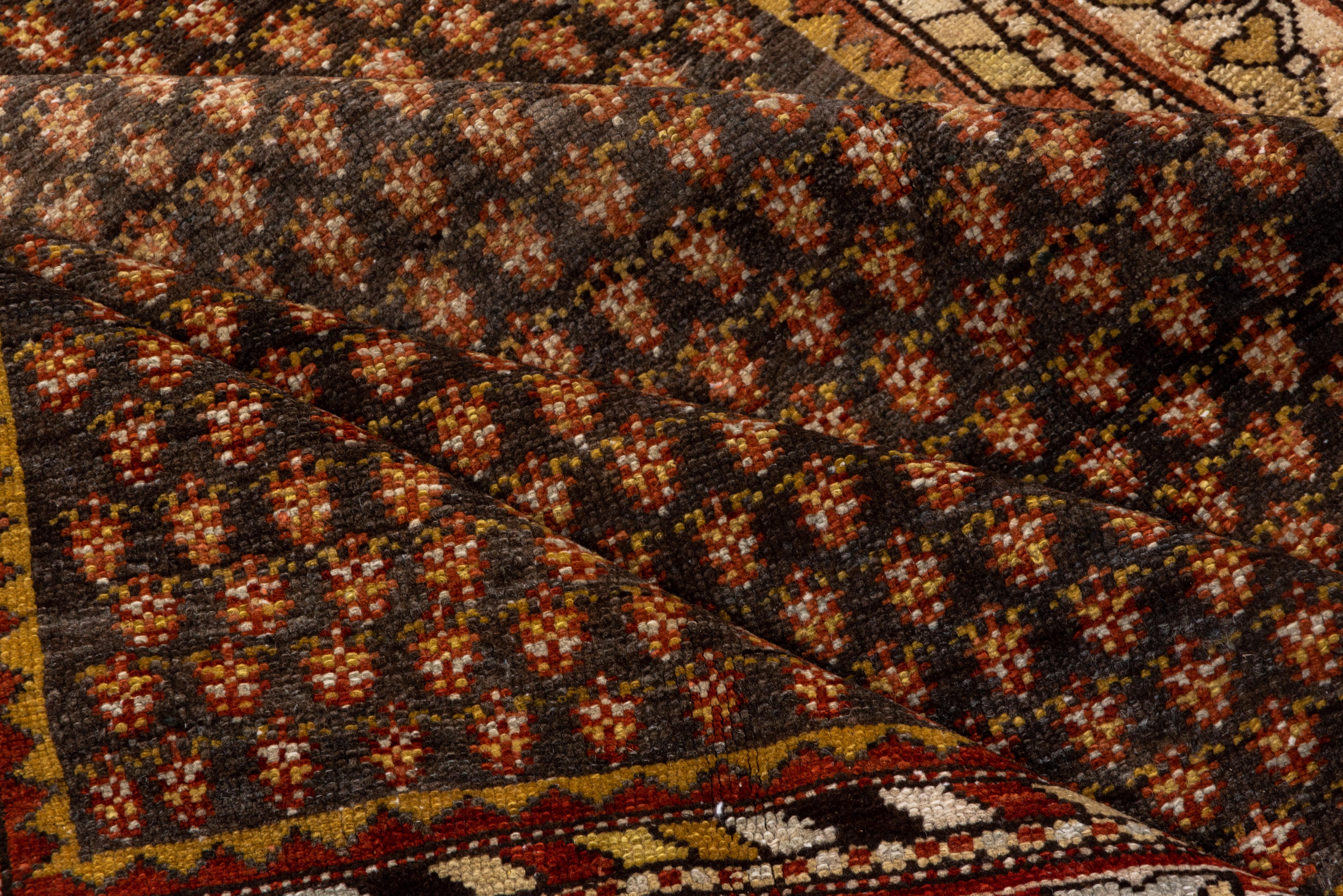 The brown-slate field shows row upon offset half-drop row of tiny flowers, not botehs, The ecru main border shows flip-flop flowers on a close meander. Minor borders with colour-striped diagonals. Medium village weave from western Persia on cotton.