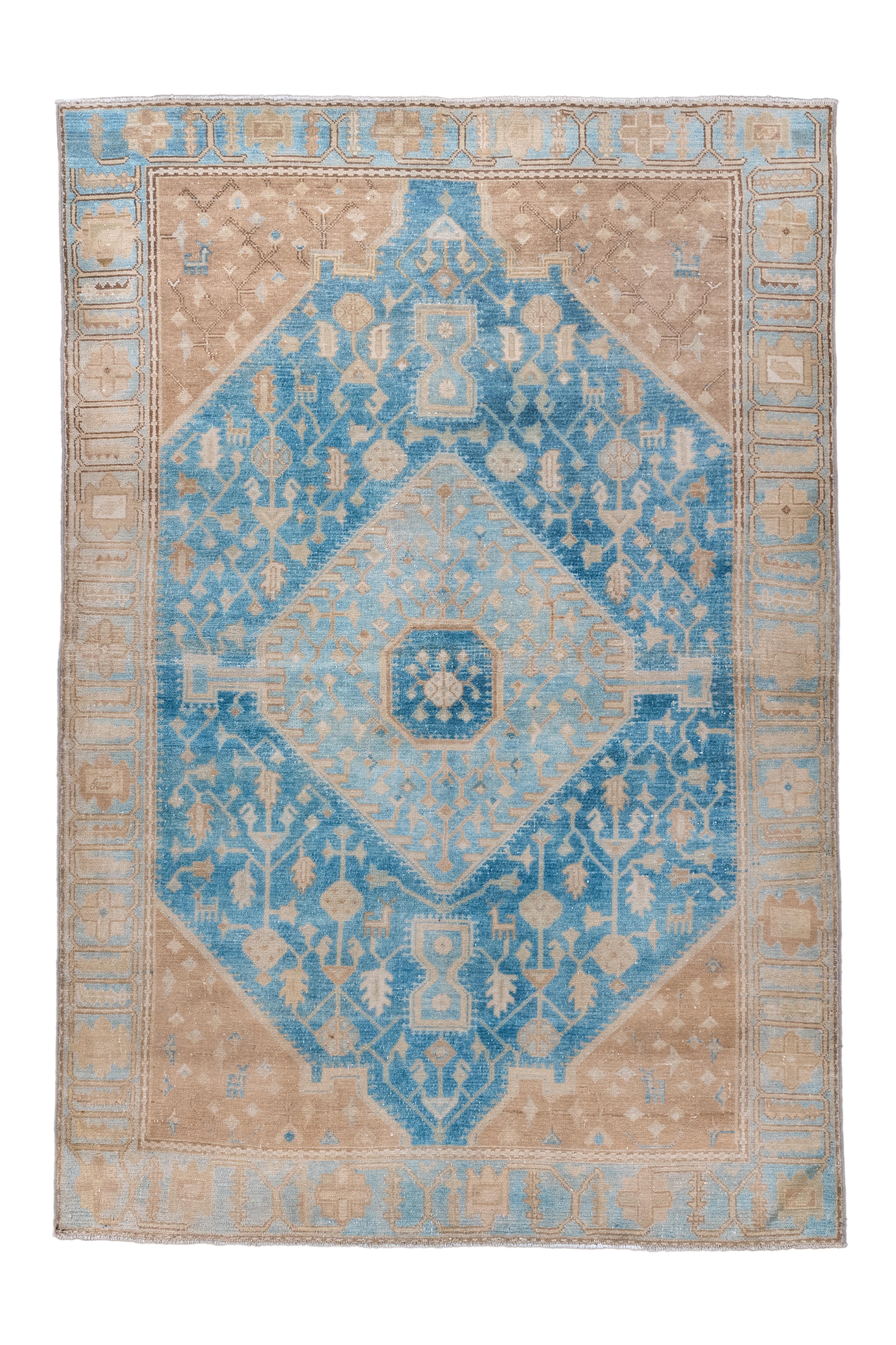 Questo antico tappeto persiano Malayer, tessuto intorno al 1900, presenta un sorprendente medaglione centrale blu cielo incorniciato da pennacchi angolari color cammello e da un intricato bordo color avorio. La tavolozza audace e i motivi geometrici