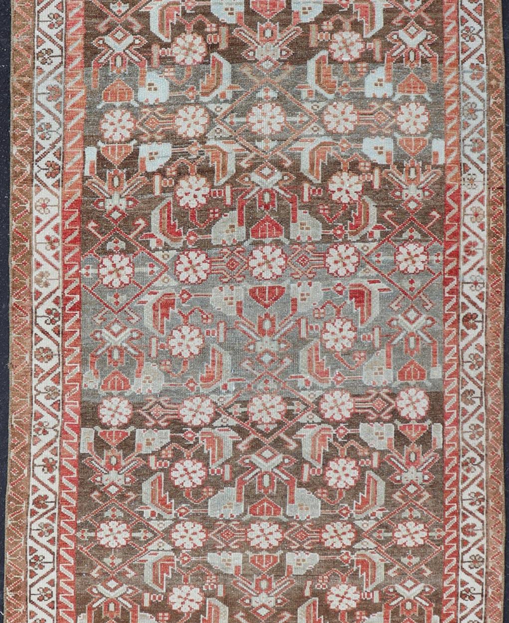 This antique Persian Malayer Runner features a sub-geometric floral design with a complementary multi-tiered border. The runner is rendered in red and earthy tones making this rug a perfect fit for a variety of classic, traditional and transitional