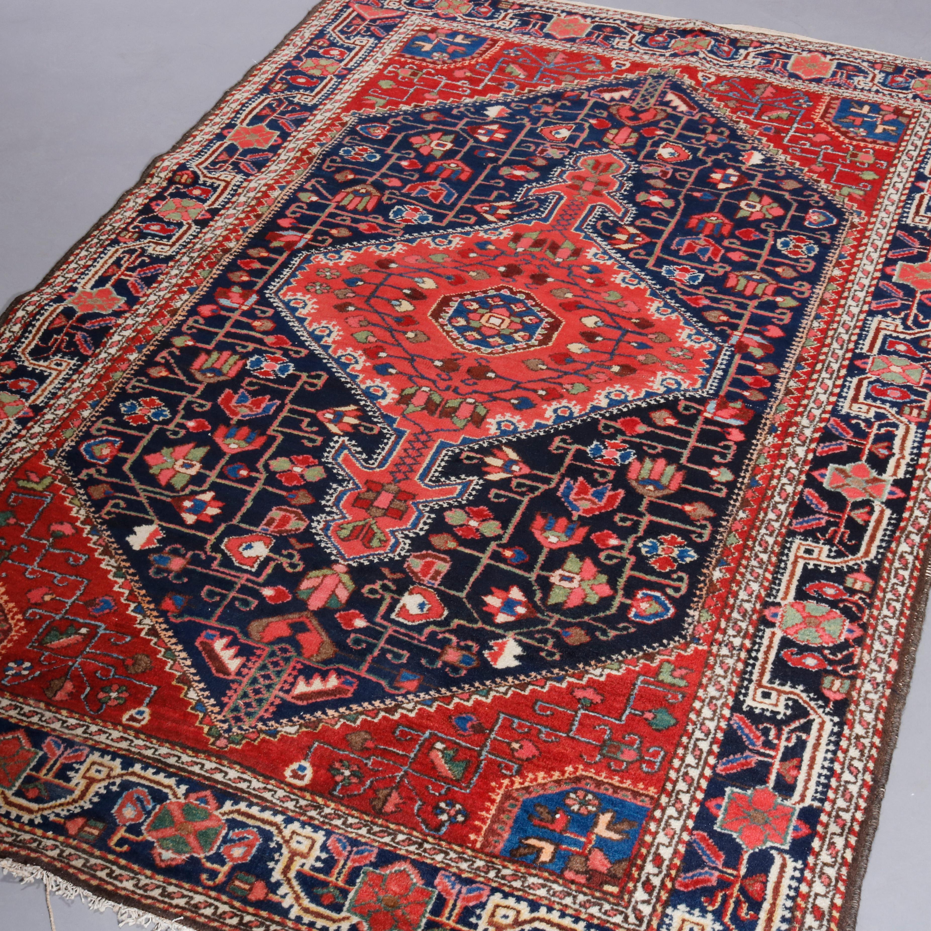 An antique Persian Malayer oriental rug offers wool construction having central geometric medallion and stylized floral elements throughout, c1930

Measures: 78.25