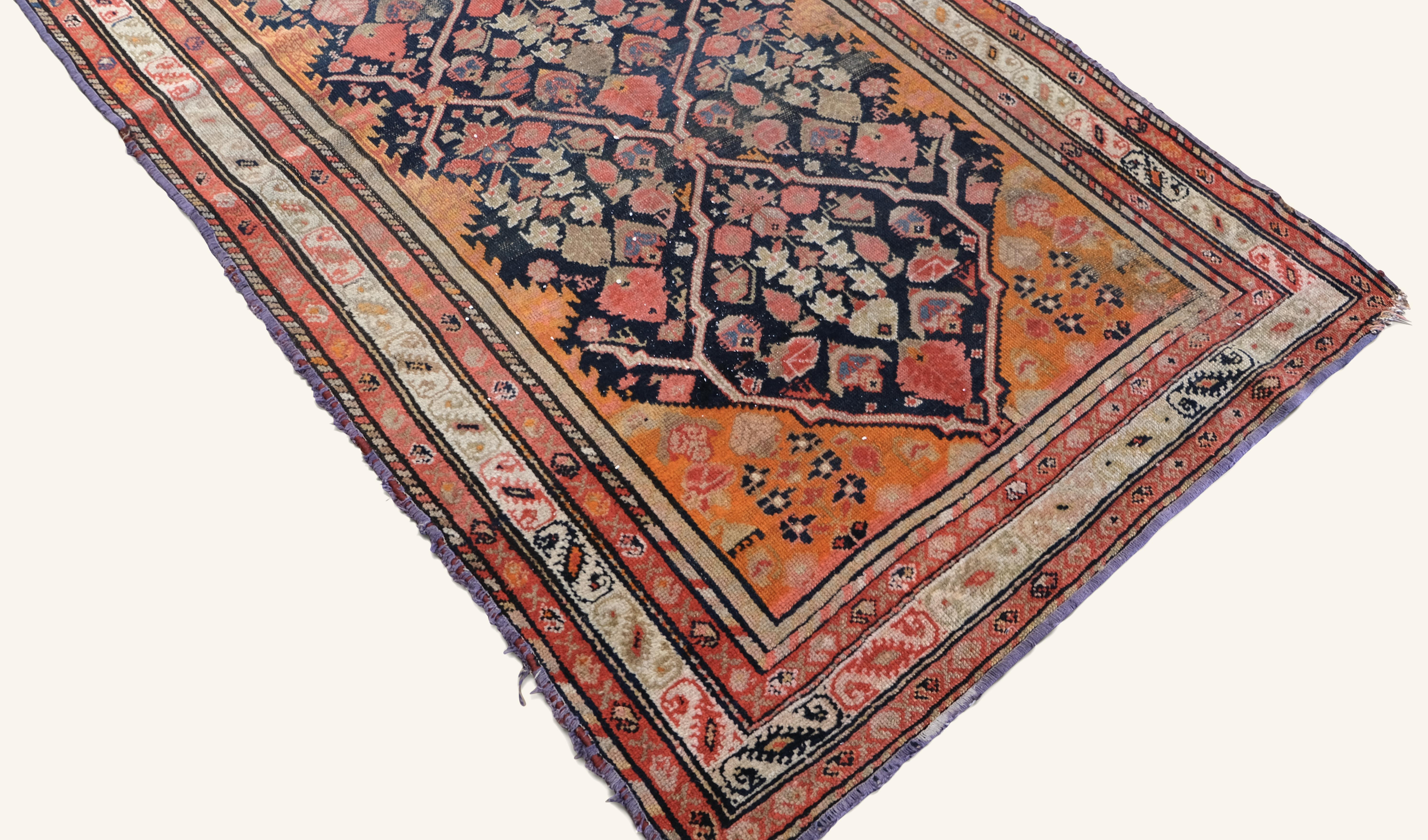 Dieser antike Teppich ist ein eindrucksvolles Beispiel traditioneller Stammeskunst, handgeknüpft aus Wolle mit einem komplizierten geometrischen Medaillonmuster. Das Design zeichnet sich durch ein kühnes zentrales Rautengitter aus, das mit