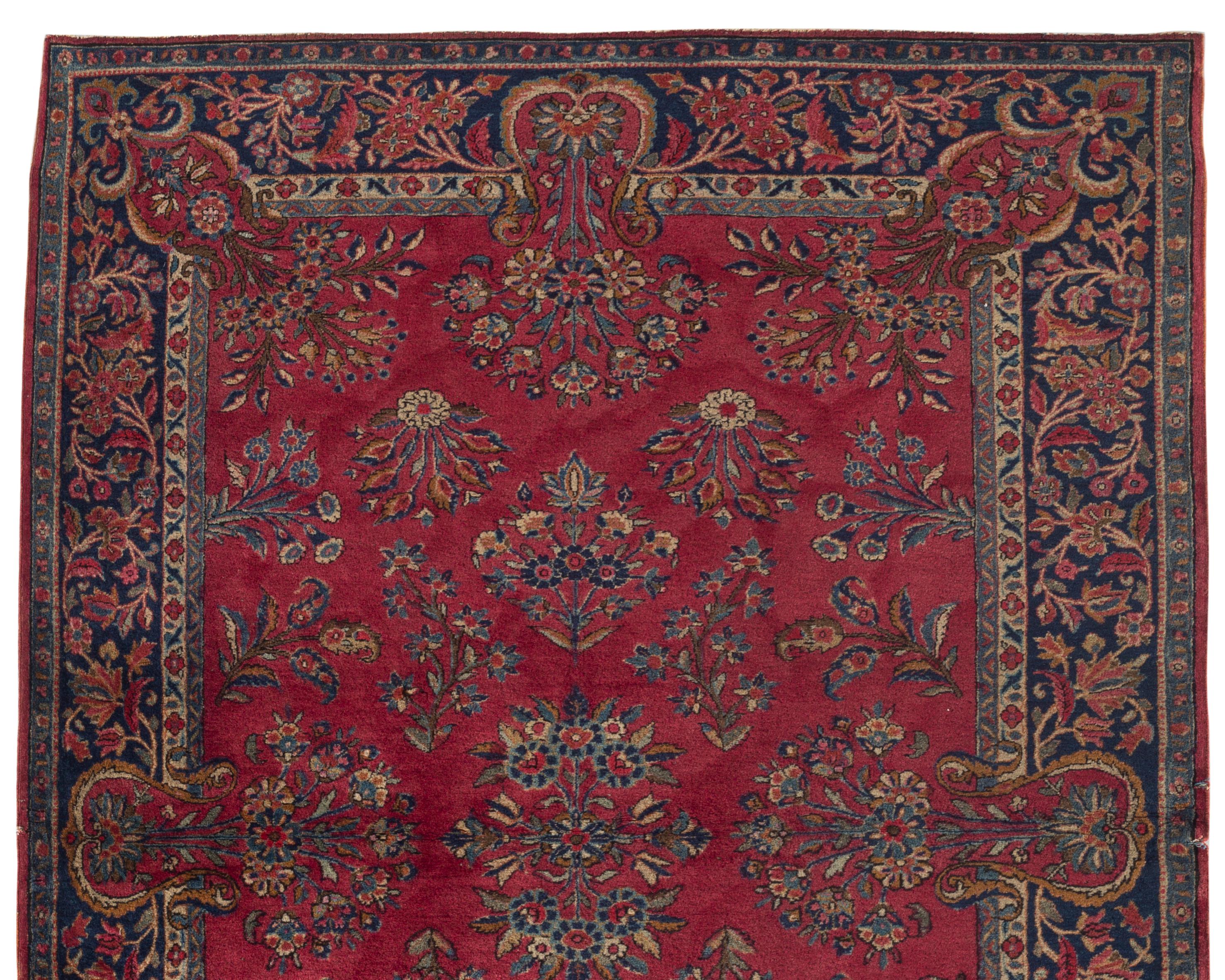 Antique Persian Manchester Kashan, circa 1900. The wonderful red field with bold floral motifs surrounded by a navy border gives this rug a look and feel of quality and importance. The term Manchester signifies that the wool used is very special, it