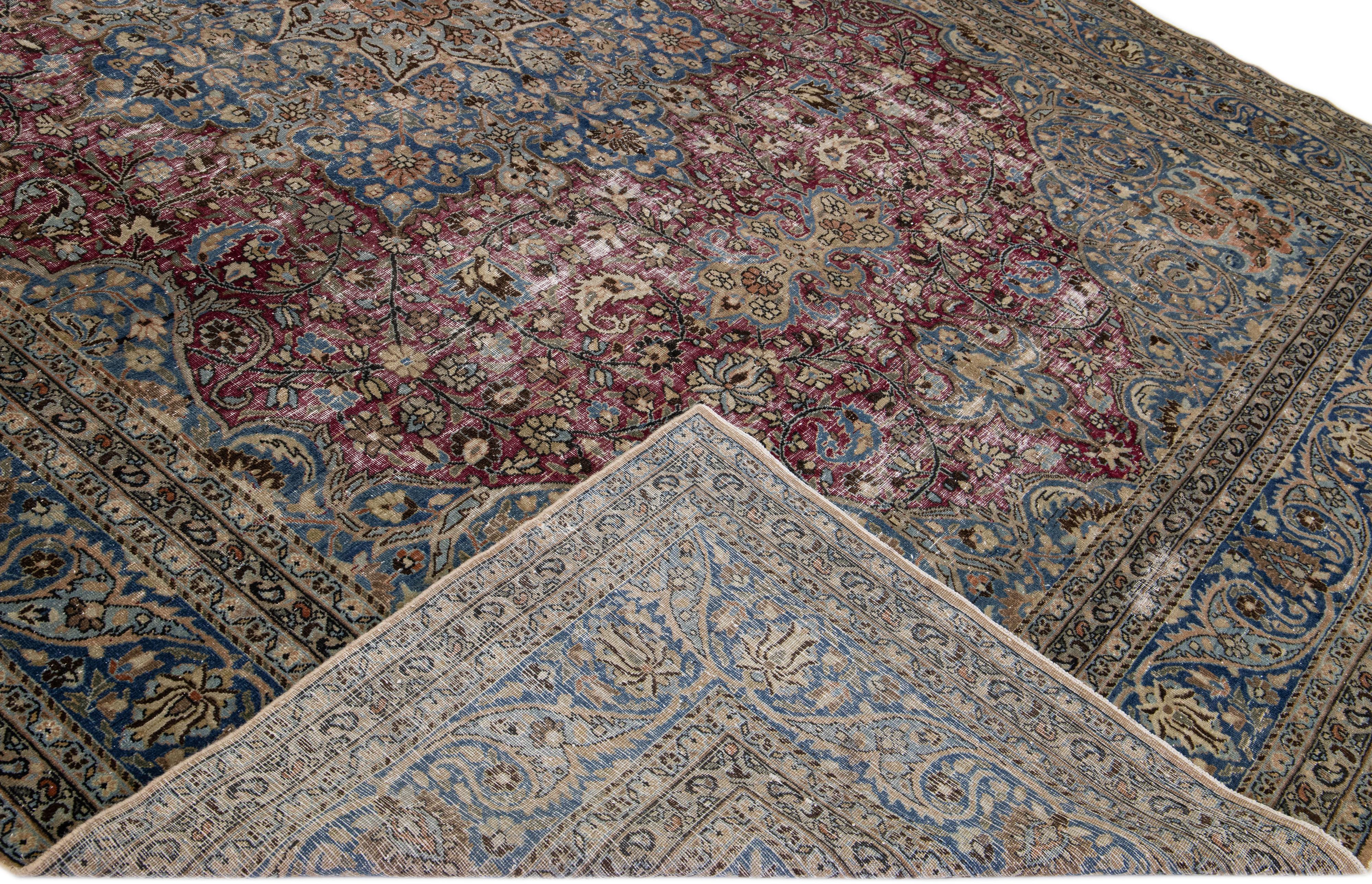 Beautiful Antique Mashad hand-knotted wool rug with a red field. This piece rug has a blue frame and accents in a gorgeous all-over classic medallion floral design. 

This rug measures: 10'7