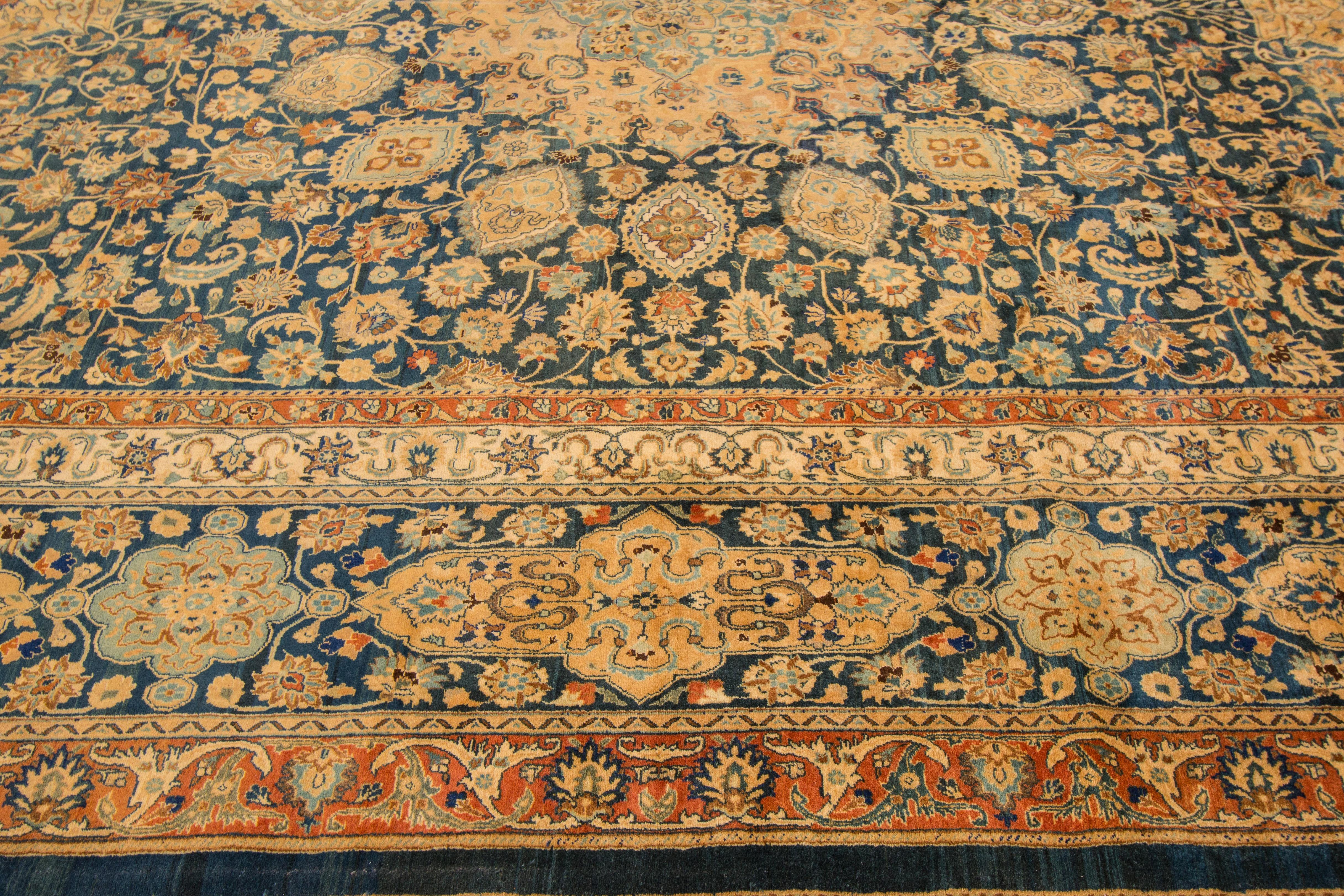 A hand-knotted antique Mashad rug with a medallion floral design. This rug measures: 11'4