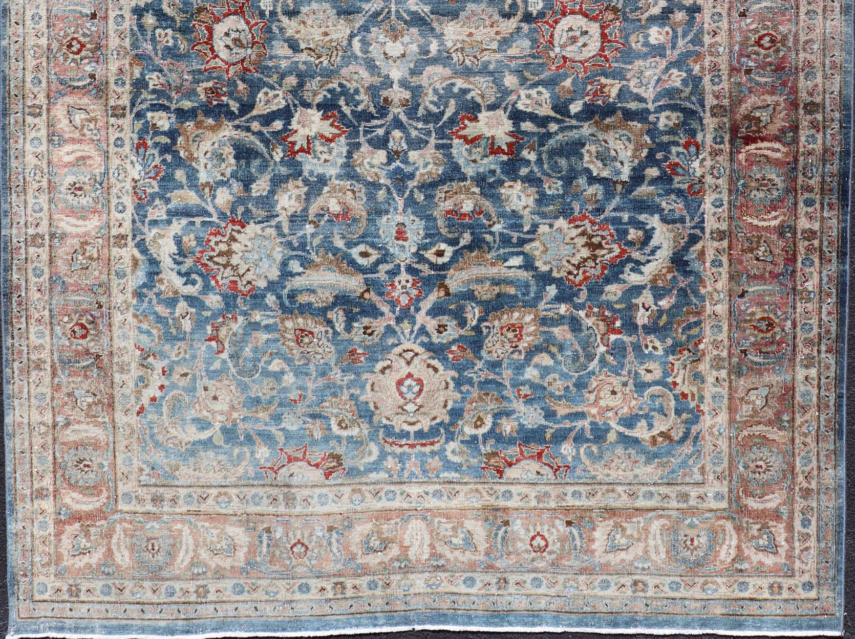 Antiker persischer Mashad-Teppich mit blauem Hintergrund und hellrosa Bordüre. Vorleger / R20-0824
Mashad ist eine Großstadt im Nordosten Irans in der Provinz Khorossan. Dieser antike Mashhad-Teppich zeigt ein botanisches Allover-Muster mit