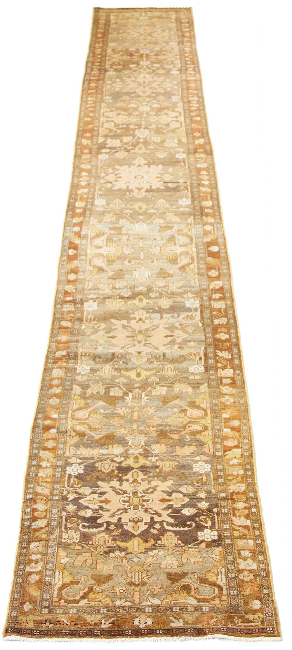 Antique Persian runner rug handwoven from the finest sheep’s wool and colored with all-natural vegetable dyes that are safe for humans and pets. It’s a traditional Mehraban design featuring floral details in pink and brown over a beige field. It’s a