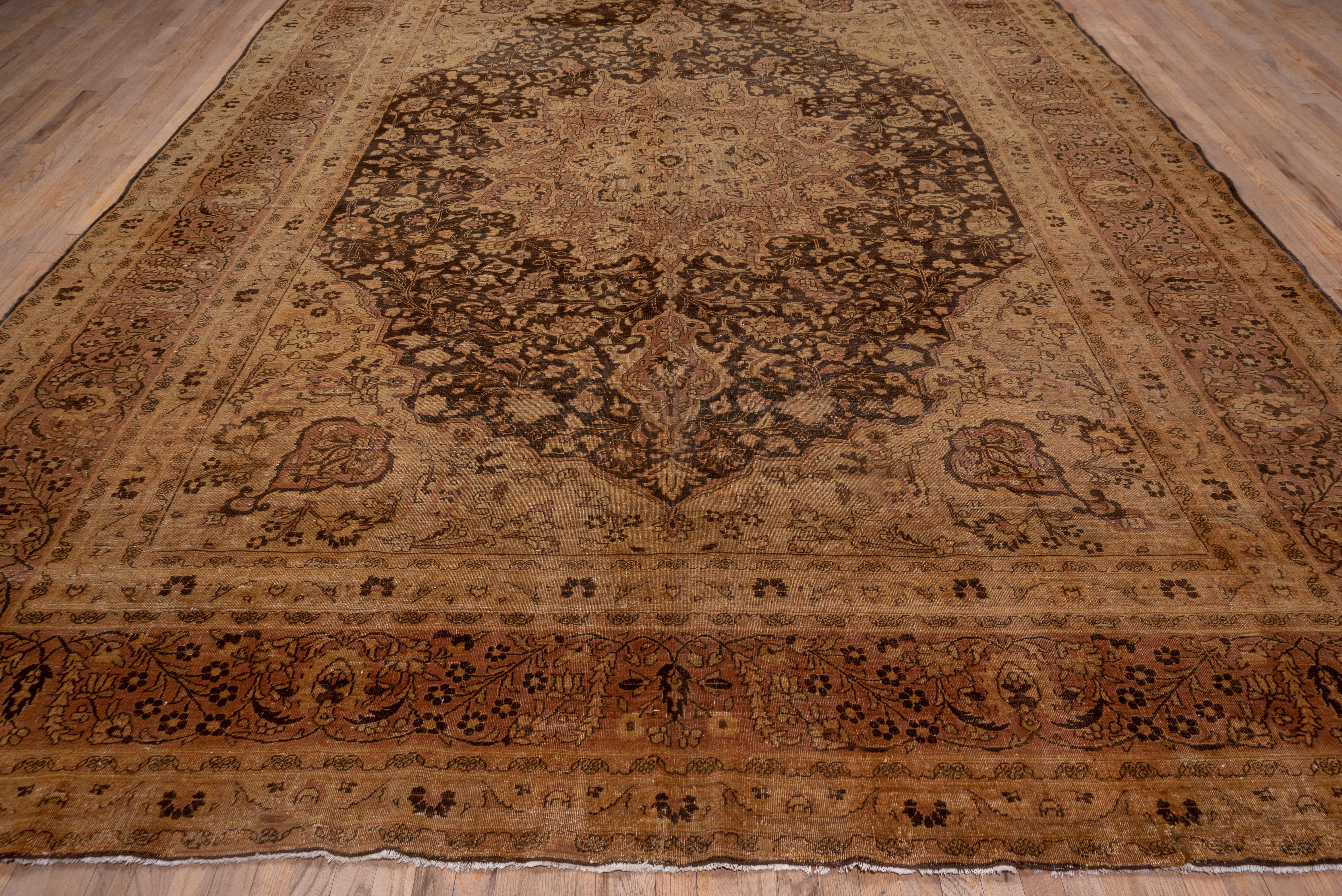 The pointed dark blue field encloses a coral-buff 16 point palmette medallion enclosing a lobed beige sub-medallion, all set within joined beige corners with grey-green escutcheon medallions. The matching main border of this well-worn NE Persian
