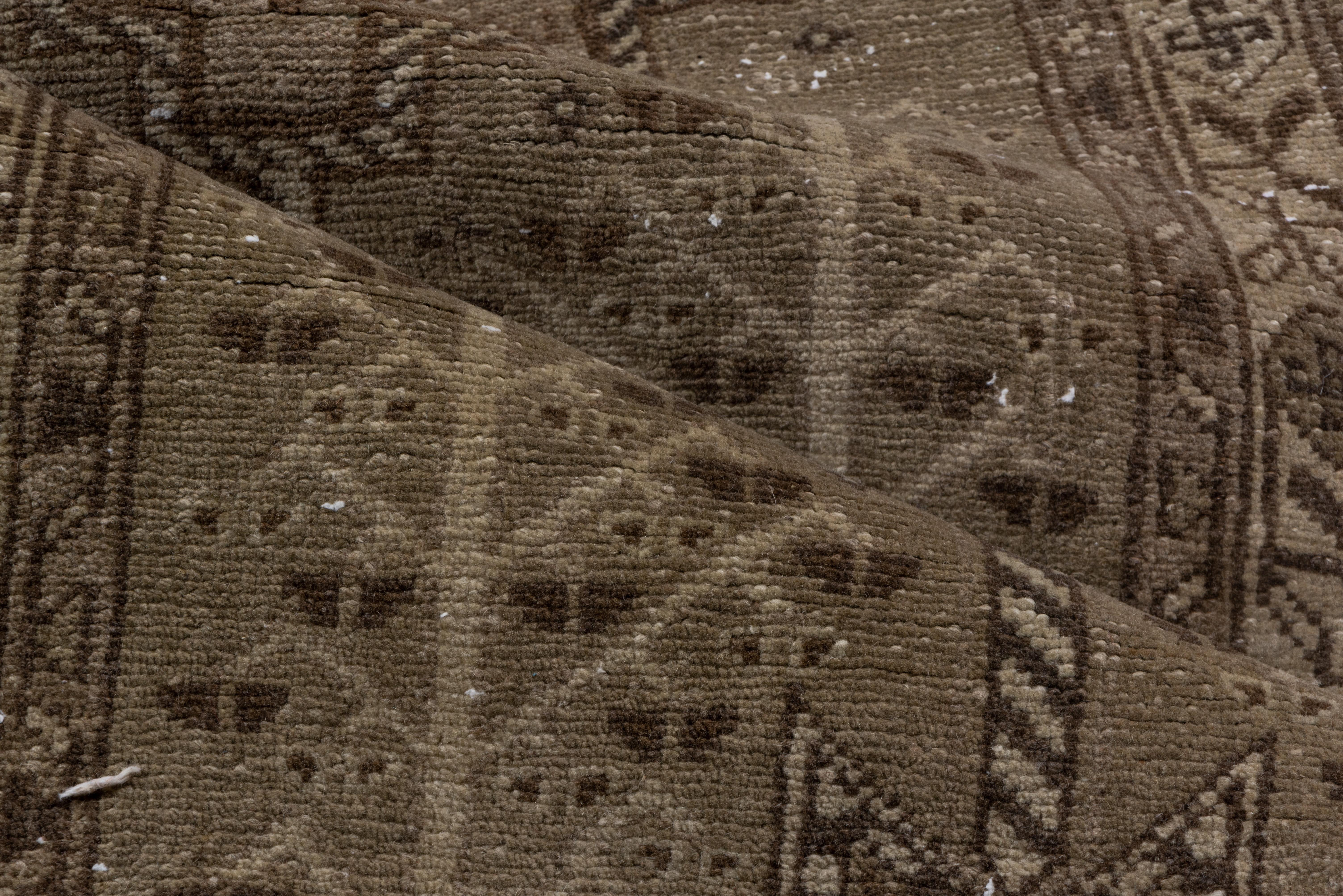 Dieser nordwestpersische Aserbaidschan-Läufer zeigt ein Stabmedaillon aus fünf stufenförmig angeordneten Medaillons in Brauntönen auf einem braunen Feld, das gleichmäßig Blumen mit vier symmetrischen Rosetten einschließt. Blüten mit gebrochenen
