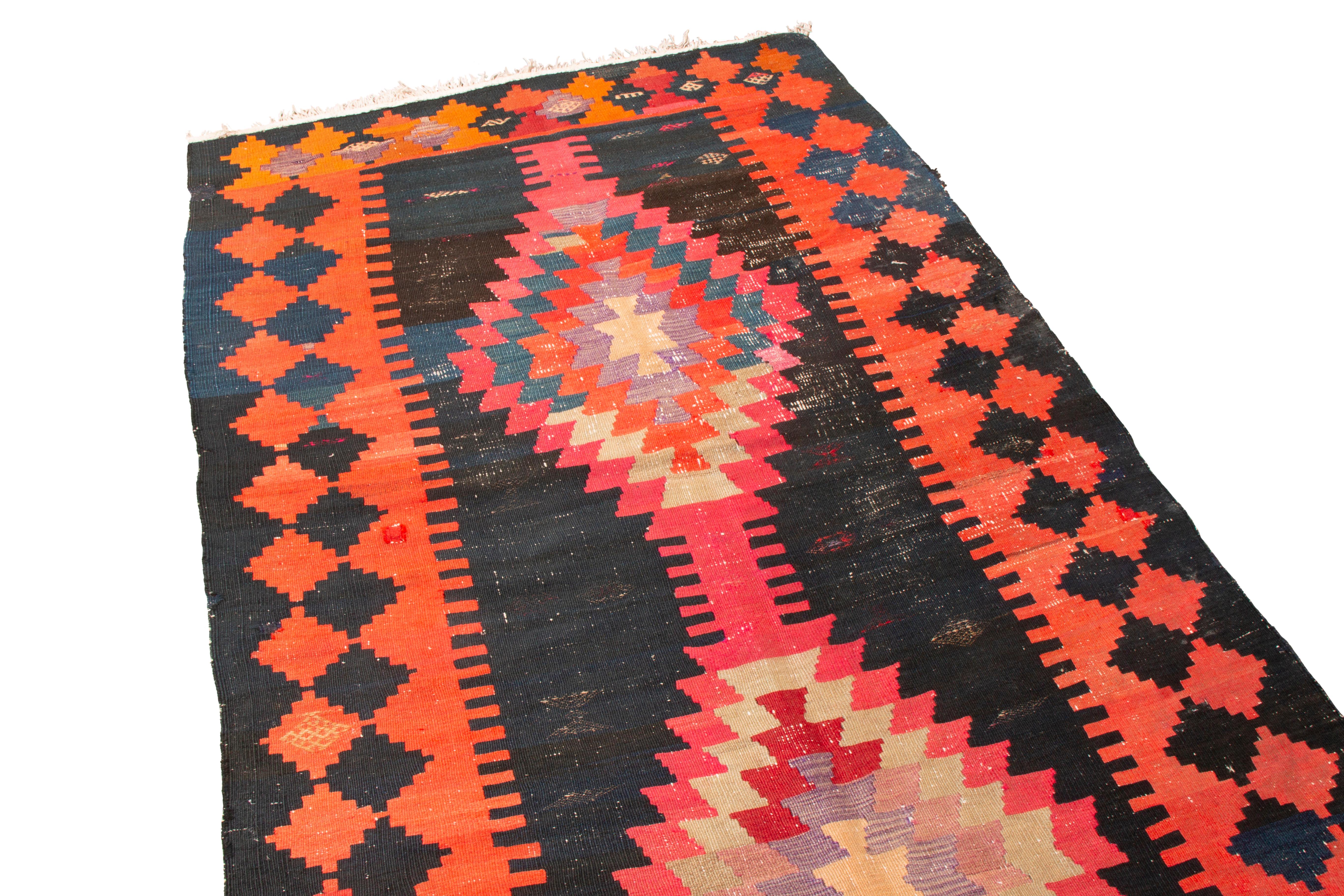 Originating from Persia in 1920, this antique Persian wool kilim from Rug & Kilim features an uncommon combination of tribal colors with a culturally significant “eye” pattern. Sometimes referred to as the protective or “evil” eye, this symbol was