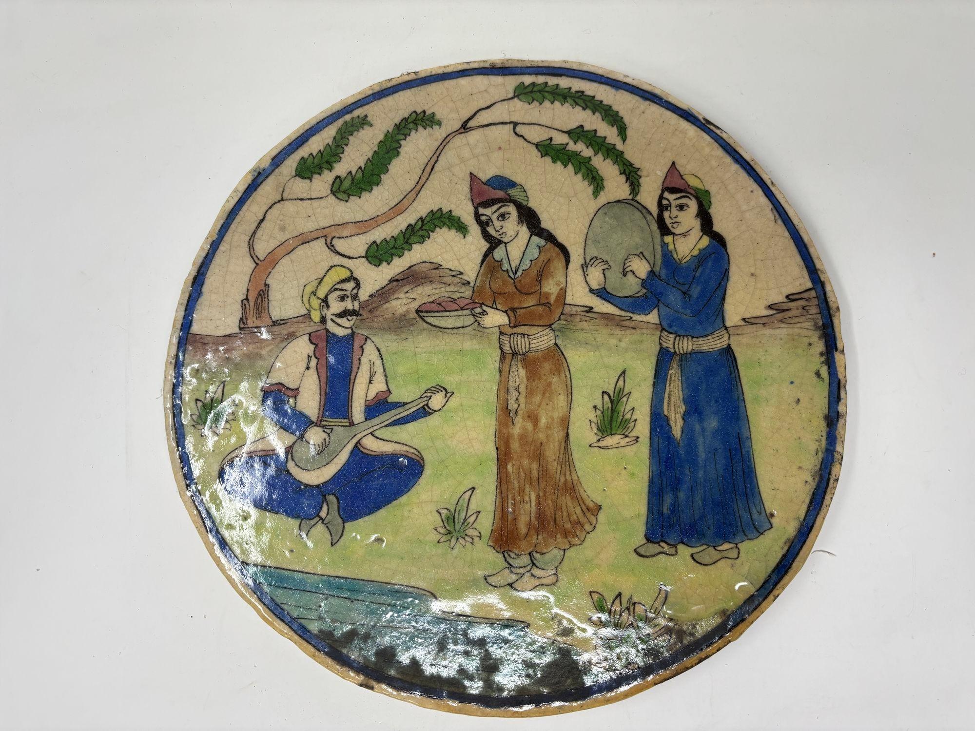 Antique Persian Qajar Middle Eastern Islamic tile plaque 19th century or before.
Asian Moorish glazed ceramic tile depicting an outdoor scene with musician and women serving food and dancing.
Beautiful Middle Eastern handcrafted decorative circular