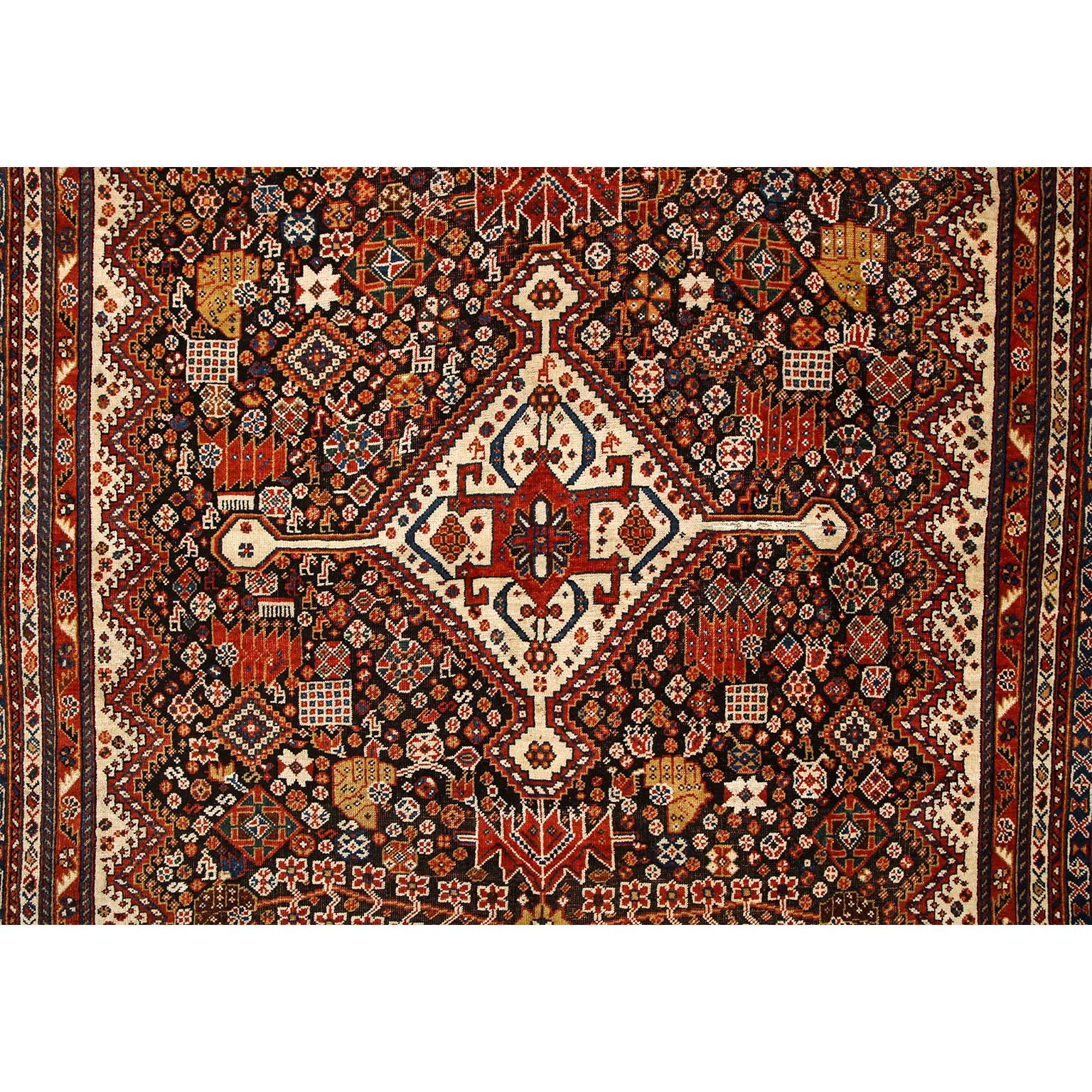 This antique Persian Kashkouli carpet in pure handspun wool and vegetable dyes circa 1900 features a central stylized 
