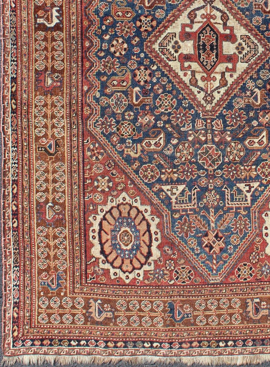 Antique Persian Qashqai rug with central medallion in ink blue and faded red, Keivan Woven Arts / rug gng-4775, country of origin / type: Iran / Qashqai, circa 1910

This antique Persian Qashqai carpet (circa early 20th century) features a central
