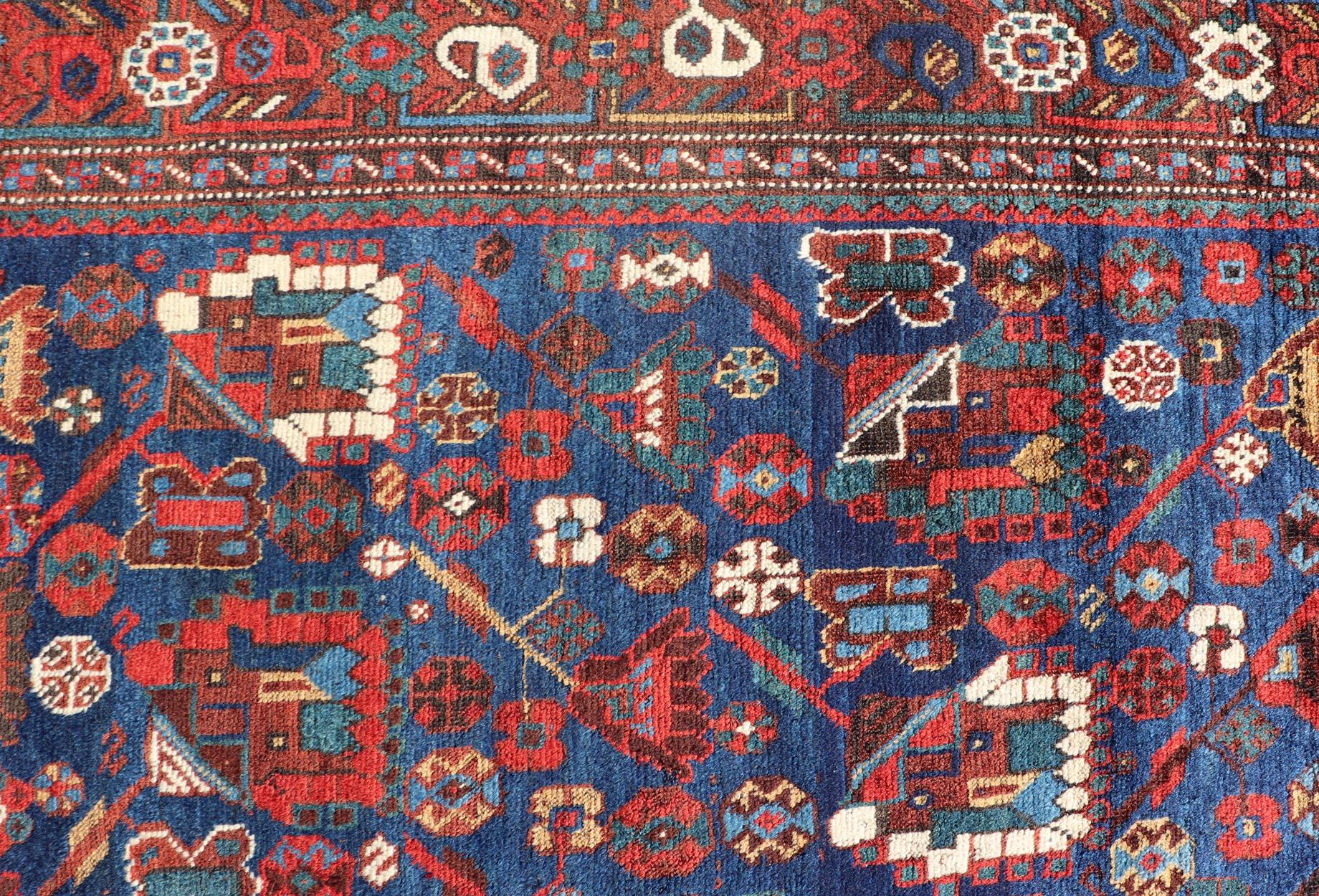Antique Persian Qashqai Shiraz Tribal Rug with Tribal Design in jewel tones with blue background. Keivan Woven Arts / rug EMB-9687-P13529, country of origin / type: Iran / Qashqai, circa 1900. 

Measures: 6'0 x 9'0.