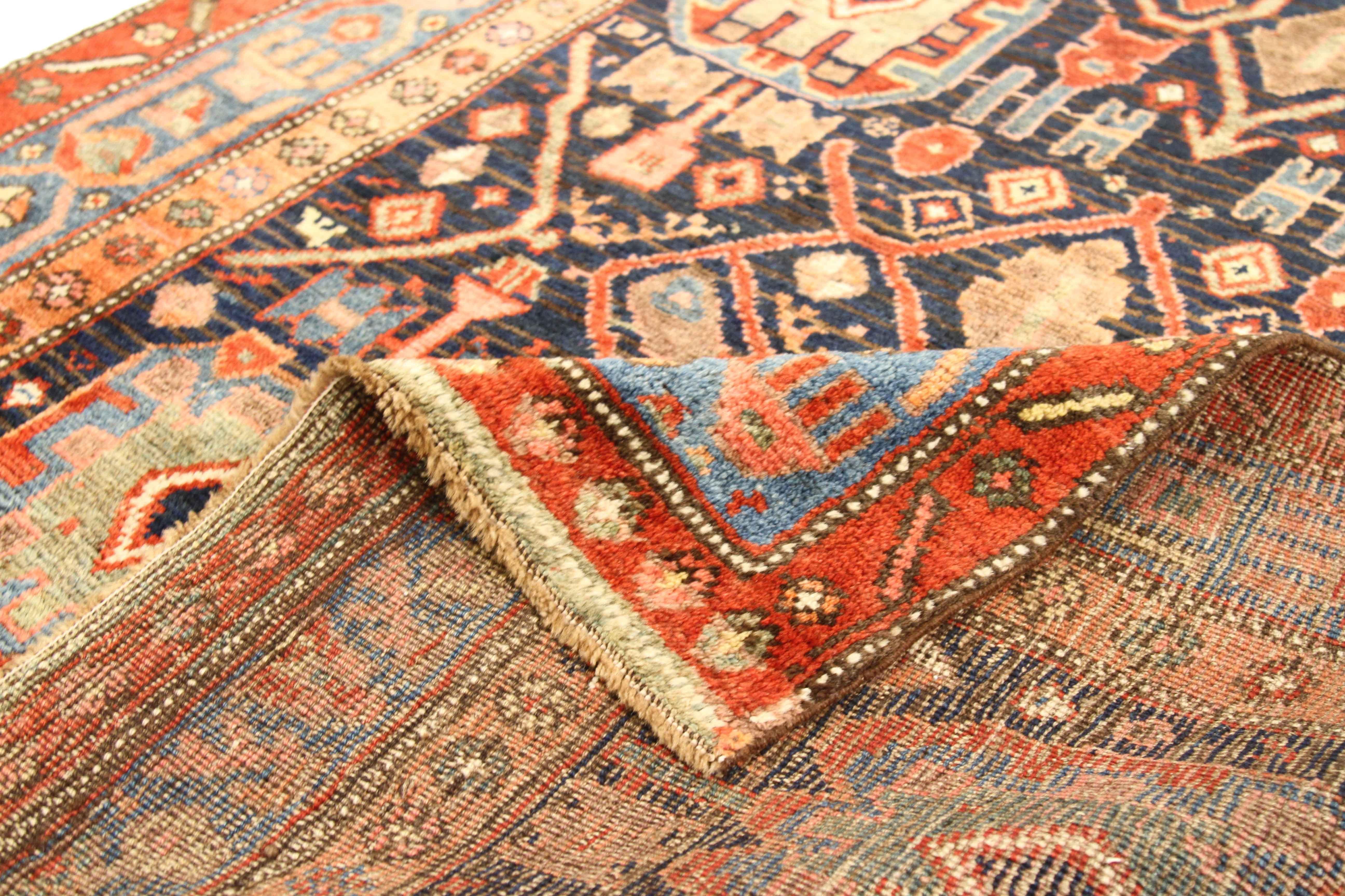 Made in the 1910s, this Persian rug is a certified antique piece woven by hand using the finest wool and dyes. Tribal patterns indigenous to weavers in Bijar fill the entire field of the carpet along with floral borders that provide an excellent