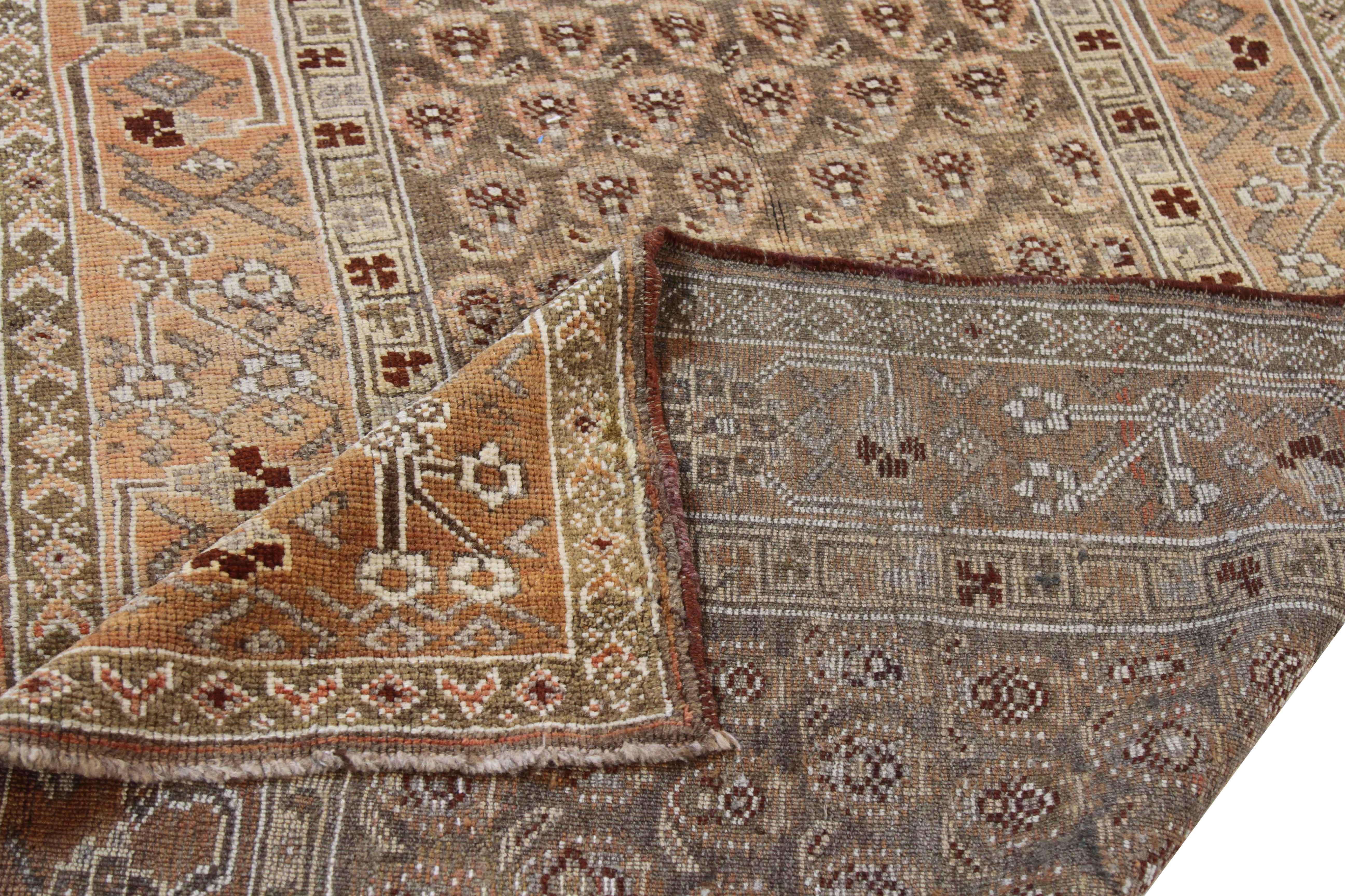 Crafted from the finest wool and vegetable dyes of the highest quality, this antique Persian rug features an elegant rendition of patterns native to Bijar weavers. The use of brown, red, rust and green is also favored by these master artisans which