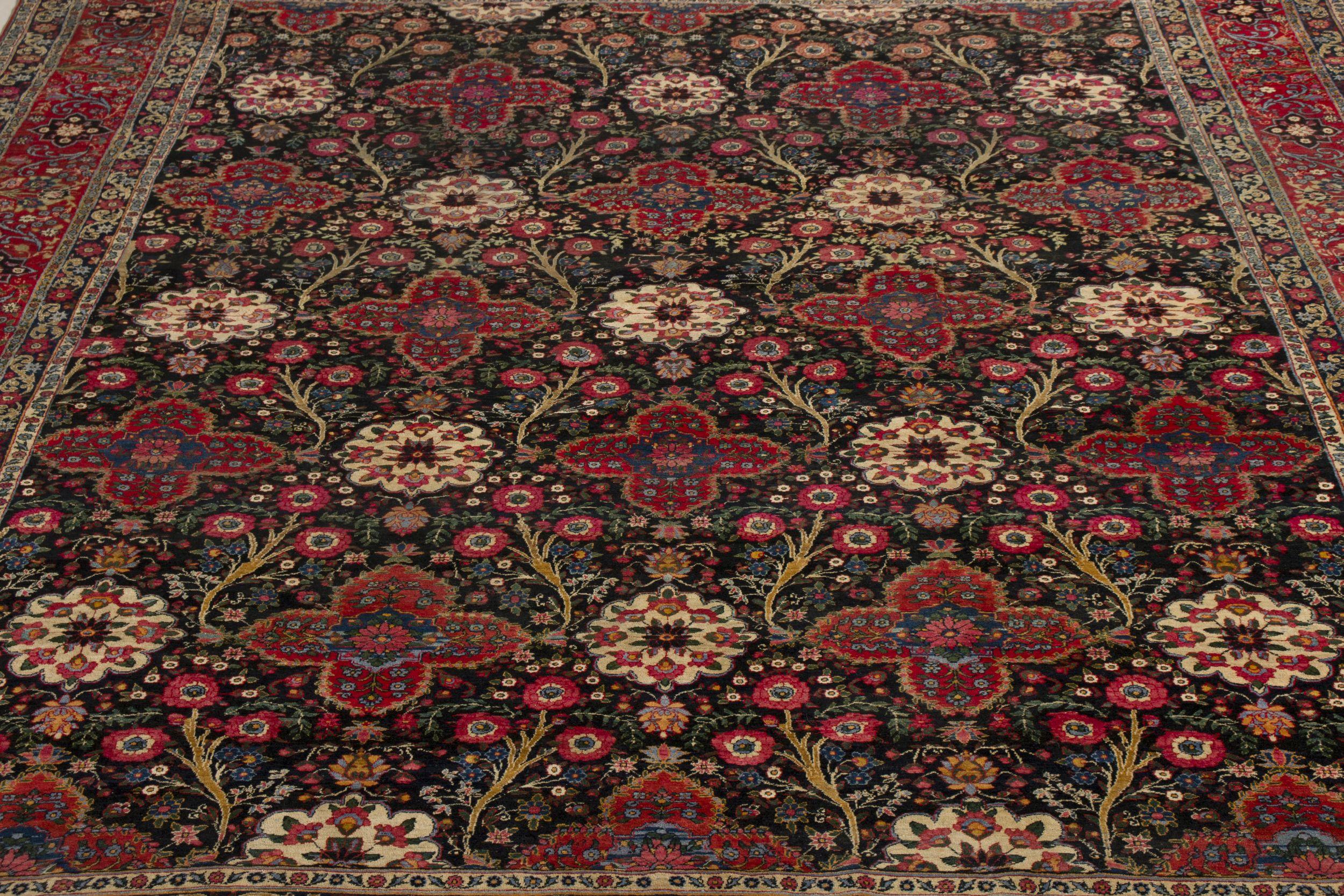 Persiano Tappeto persiano antico in nero con motivi floreali rossi - by Rug & Kilim in vendita