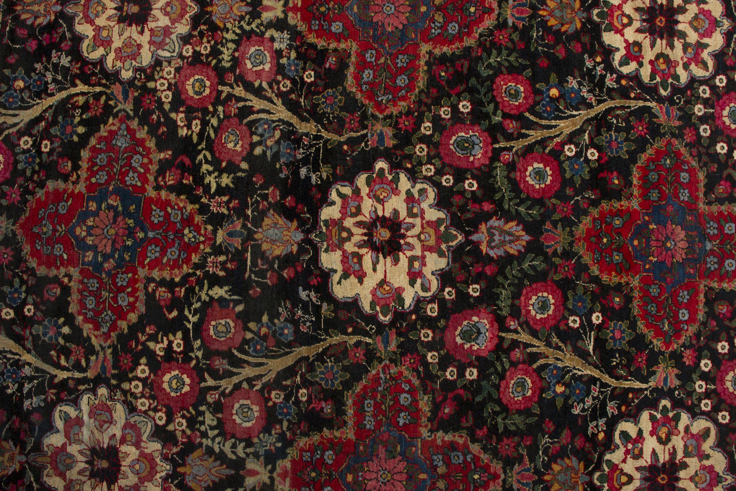 Annodato a mano Tappeto persiano antico in nero con motivi floreali rossi - by Rug & Kilim in vendita