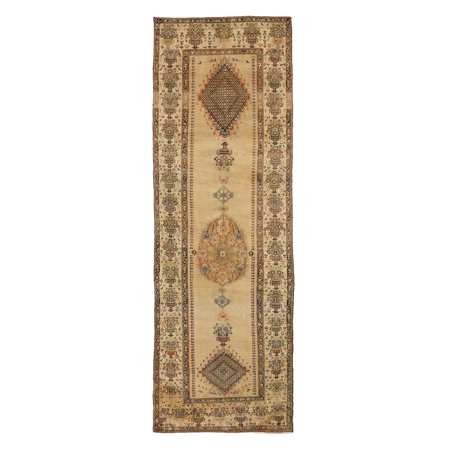Handwoven from the finest camel hair, this antique Persian Serab rug shows an ‘open field’ center design bordered by highly intricate floral and geometric patterns. It also displays several unique bluish details that look like tiny jewels from a