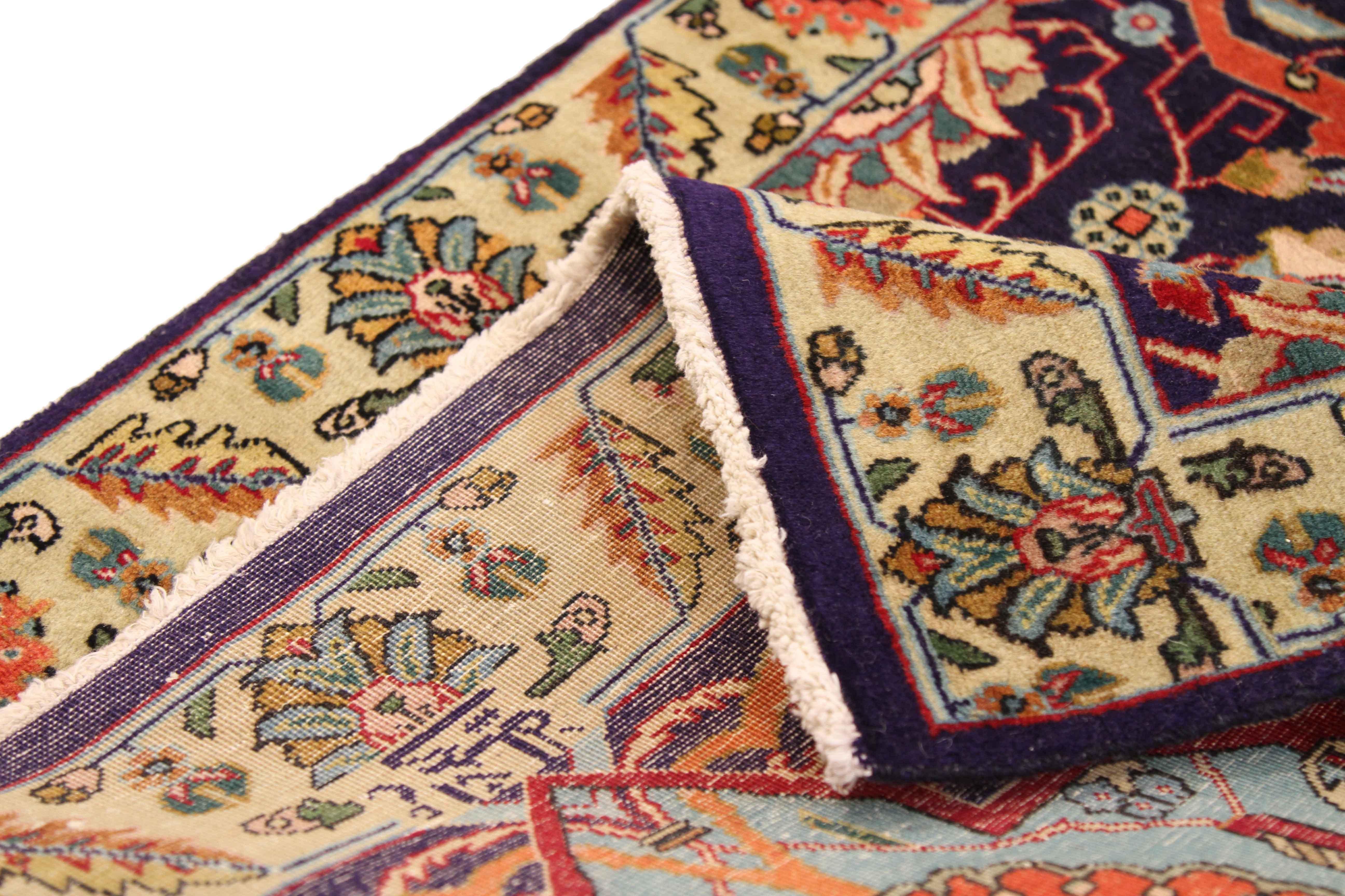 Antique Persian rug crafted with fine weaving technique showcasing the extraordinary details only found in Tabriz carpets. Blue, green, orange, navy, and ivory are blended seamlessly by intricate repeating floral patterns that make this area rug a