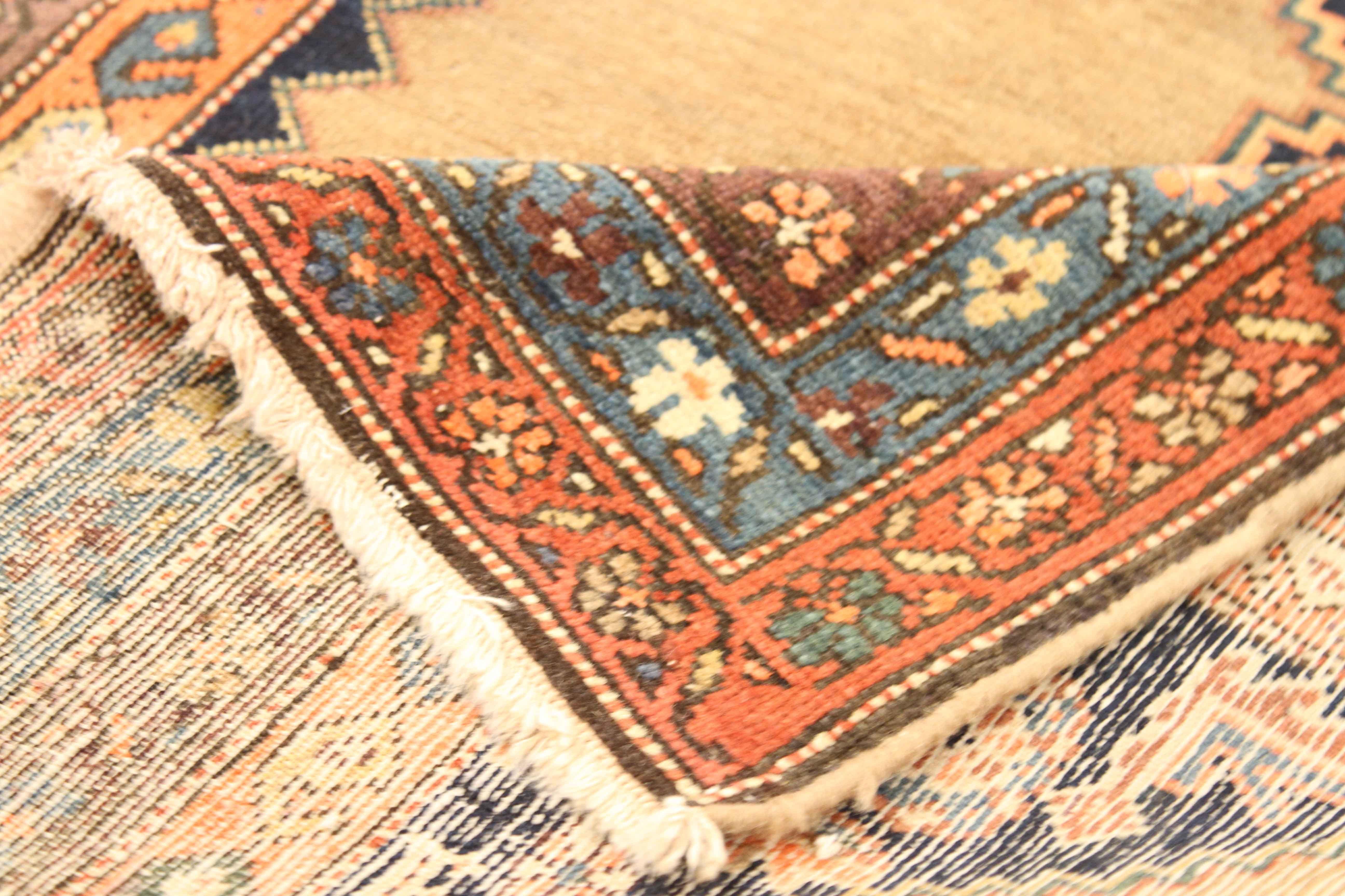 Crafted by hand using the highest quality of wool and natural dyes, this antique Persian rug features intricately-designed medallions bordered by repeating floral patterns. Made popular by Malayer weavers, this style is a great fit for modern,
