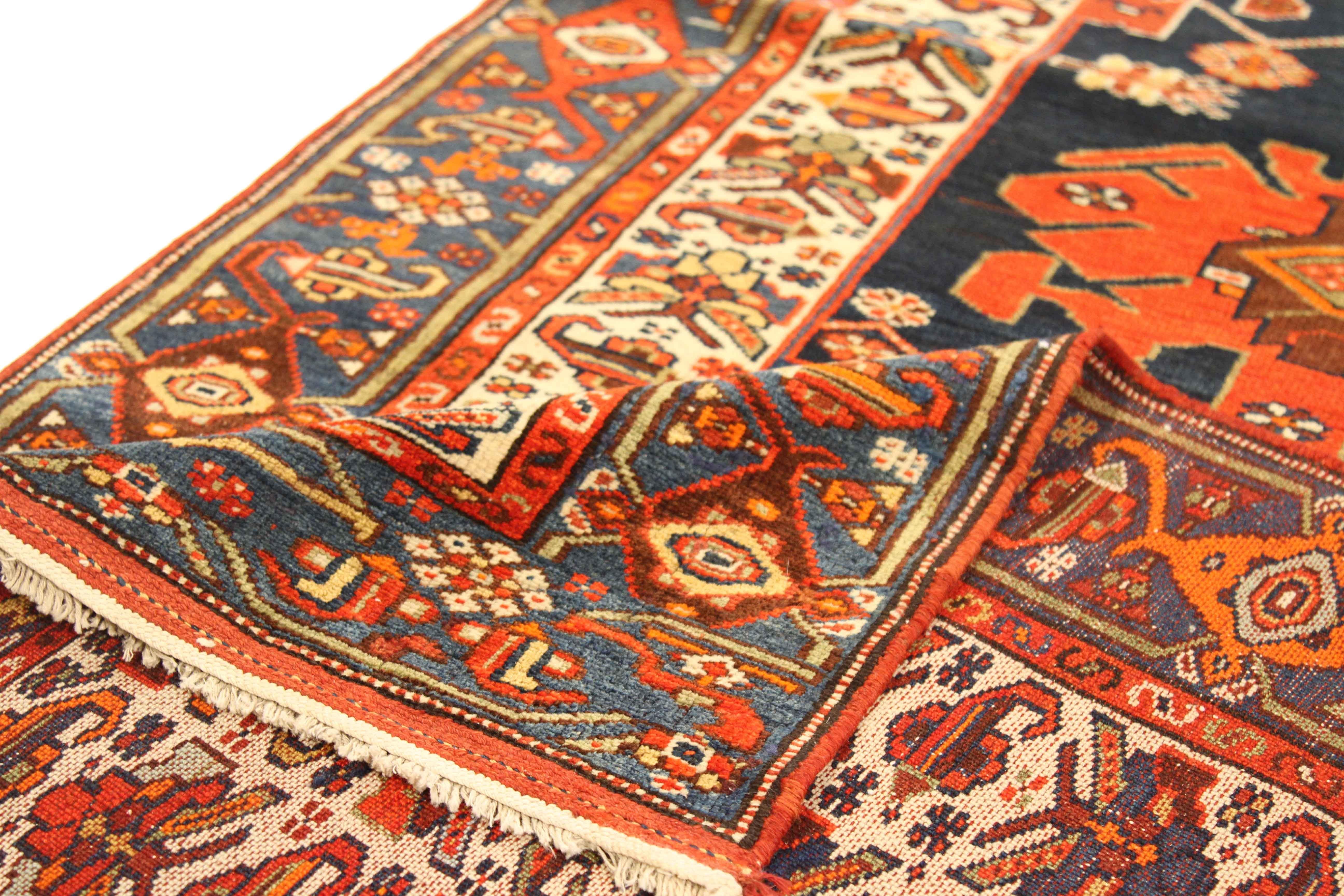 Fabriqué à la main avec de la laine fine et des teintures végétales colorées, ce tapis persan ancien présente un motif digne de la royauté avec ses grands et vifs détails géométriques. Il est encore rehaussé par le riche mélange de couleurs rouge,