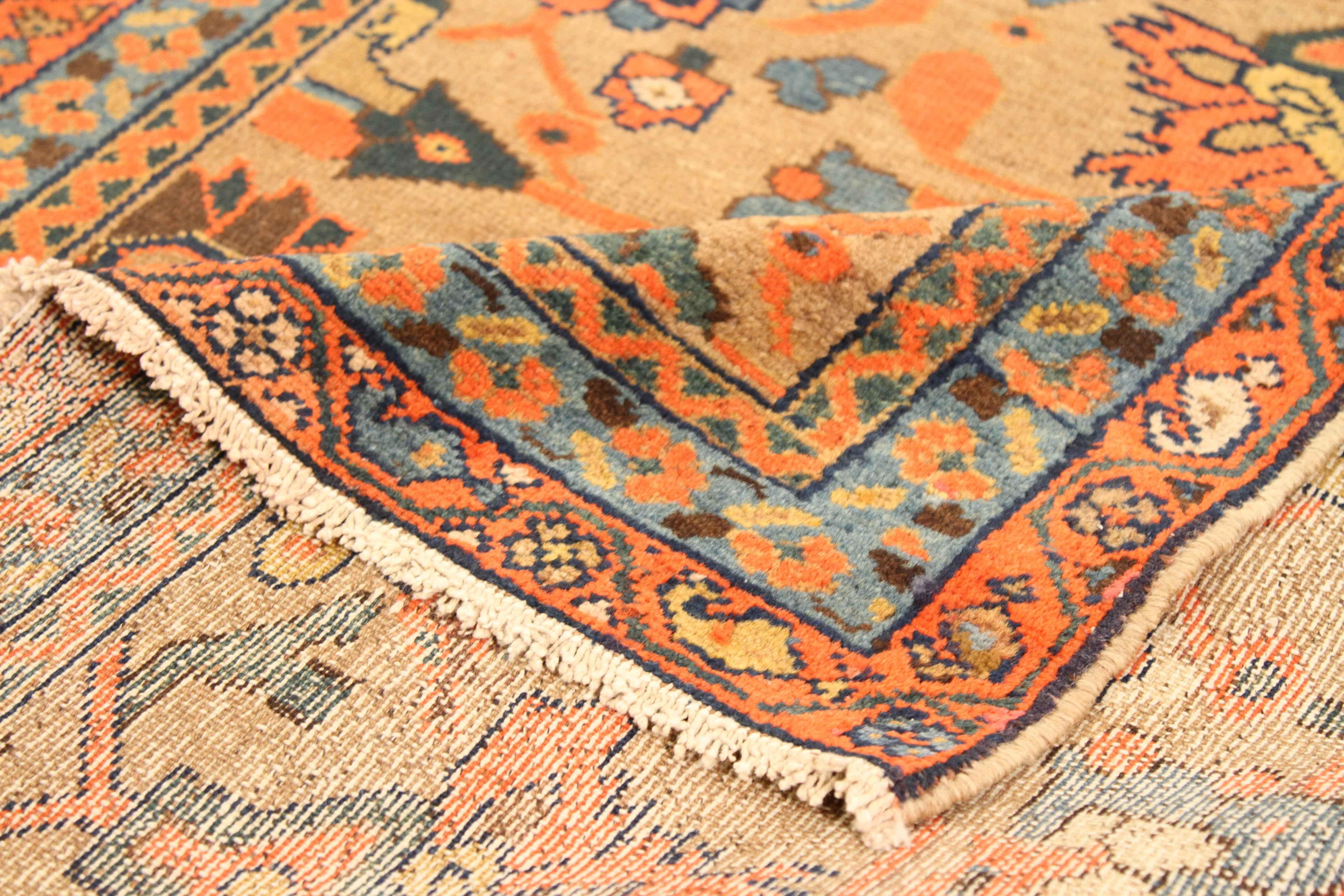 Handcrafted by hand in the 1920s, this fine wool antique Persian rug features a striking ‘field of flowers’ theme that is made even more magnificent with its chosen color palette of brown, orange, red, beige, and yellow. The details also shine