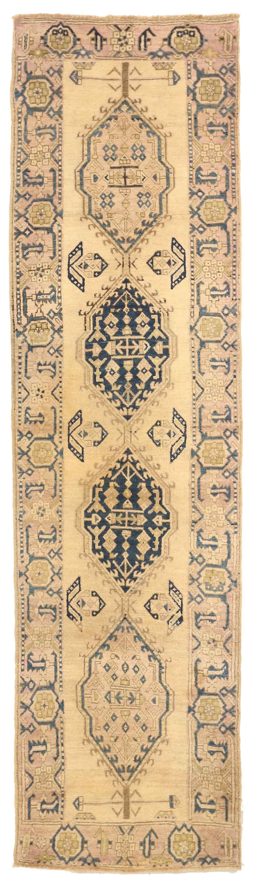 Made of fine camel hair, this antique Persian rug features a unique fusion of tribal and geometric patterns that weavers from the ancient city of Sarab are famous for. The details match perfectly with the chosen color palette of beige, navy, and