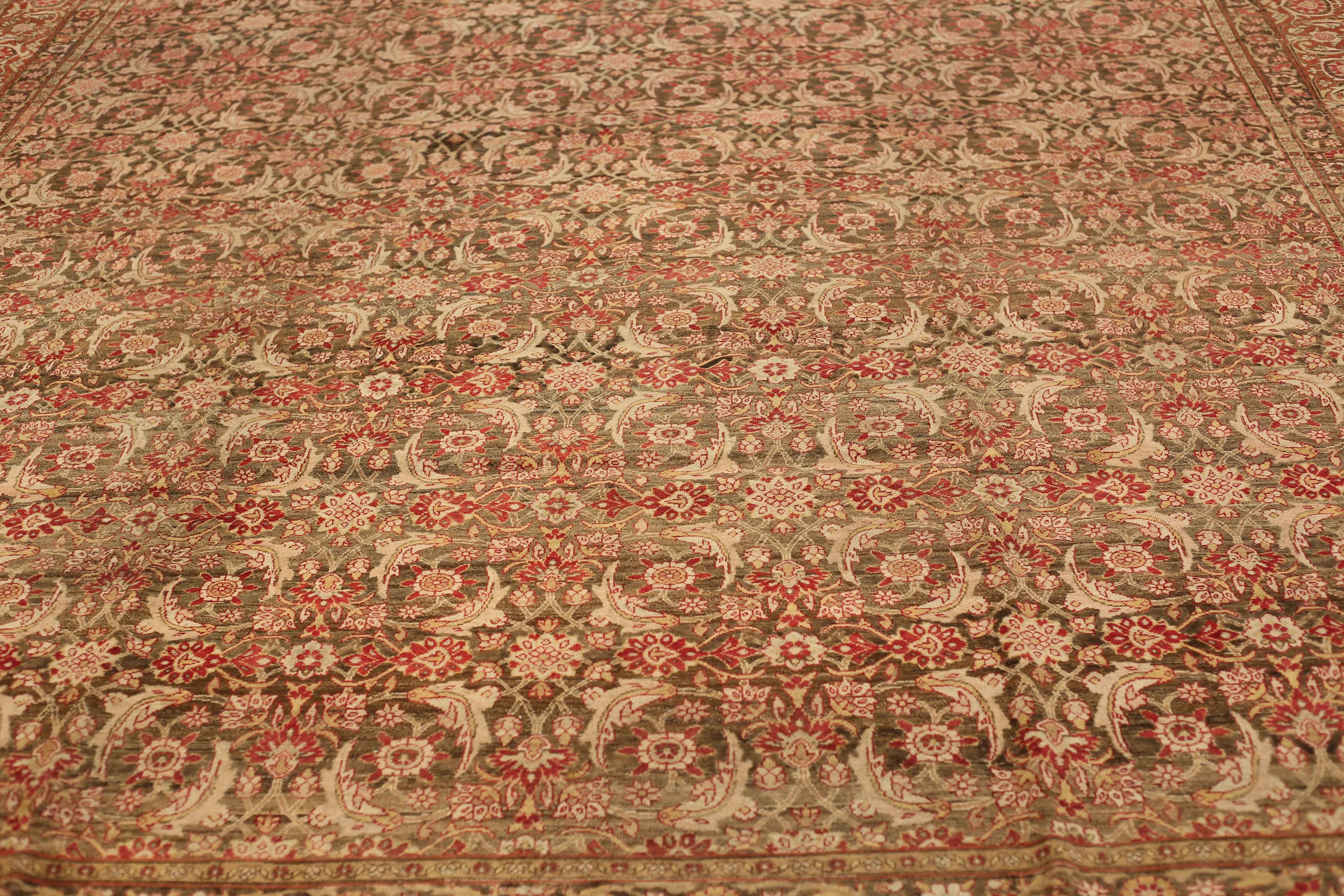 1910s-era antique handwoven wool Persian rug tinted with high quality organic dyes. It shows a stunning open field of medallions in red and pink over a beige mixed with brown backdrop. It’s ideal for spaces with contemporary, traditional, modern and