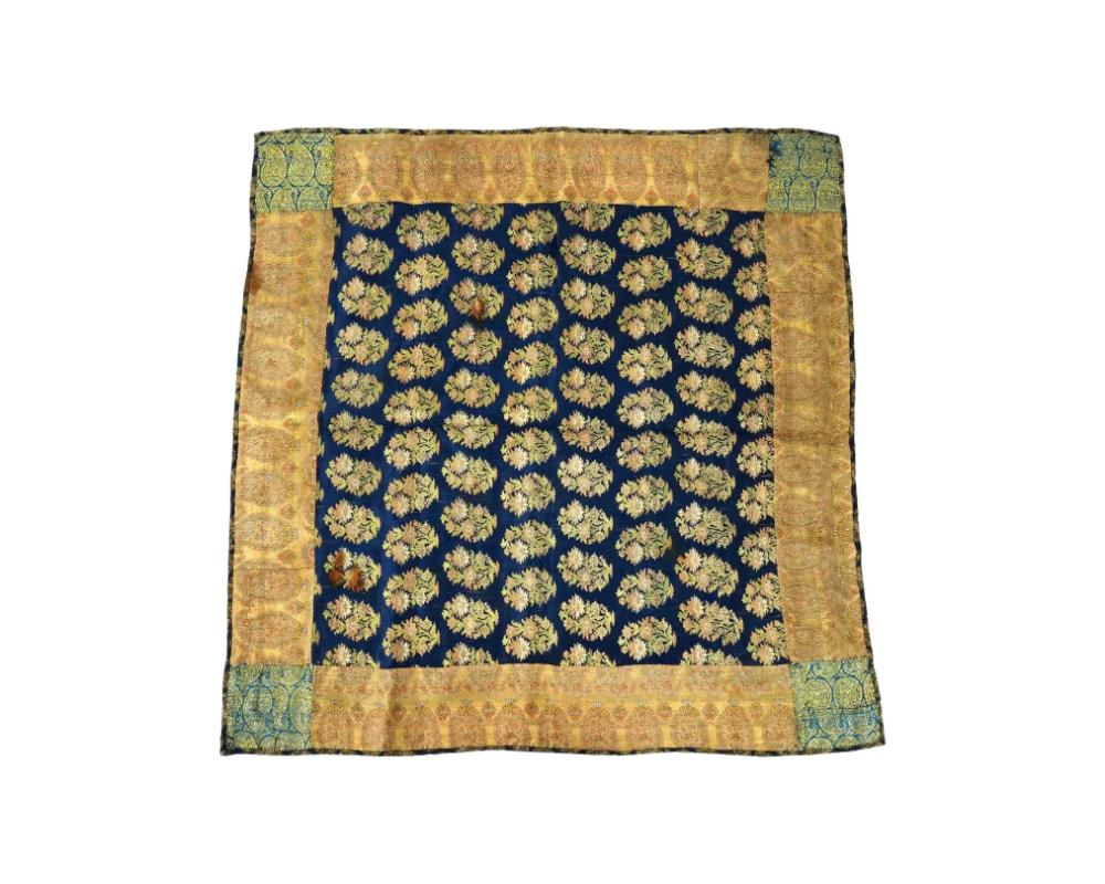 An antique Persian Iranian Safavid dynasty hand woven embroidered velvet textile. The textile is adorned with floral and foliage motifs on a deep blue background, with light brown patterned sides. Circa: 17th century. Safavid Iran or Safavid Persia,