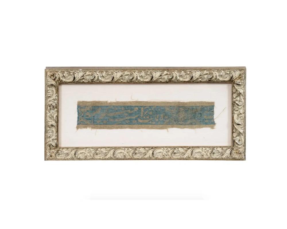 An antique Persian fragment of textile tapestry. Late Safavid dynasty, 18th century. Ilsamic calligraphy against the blue background. Canvas mat, golden frame. Collectible Furnishing And Textiles, Oriental Islamic Folk Arts And Applied Arts,