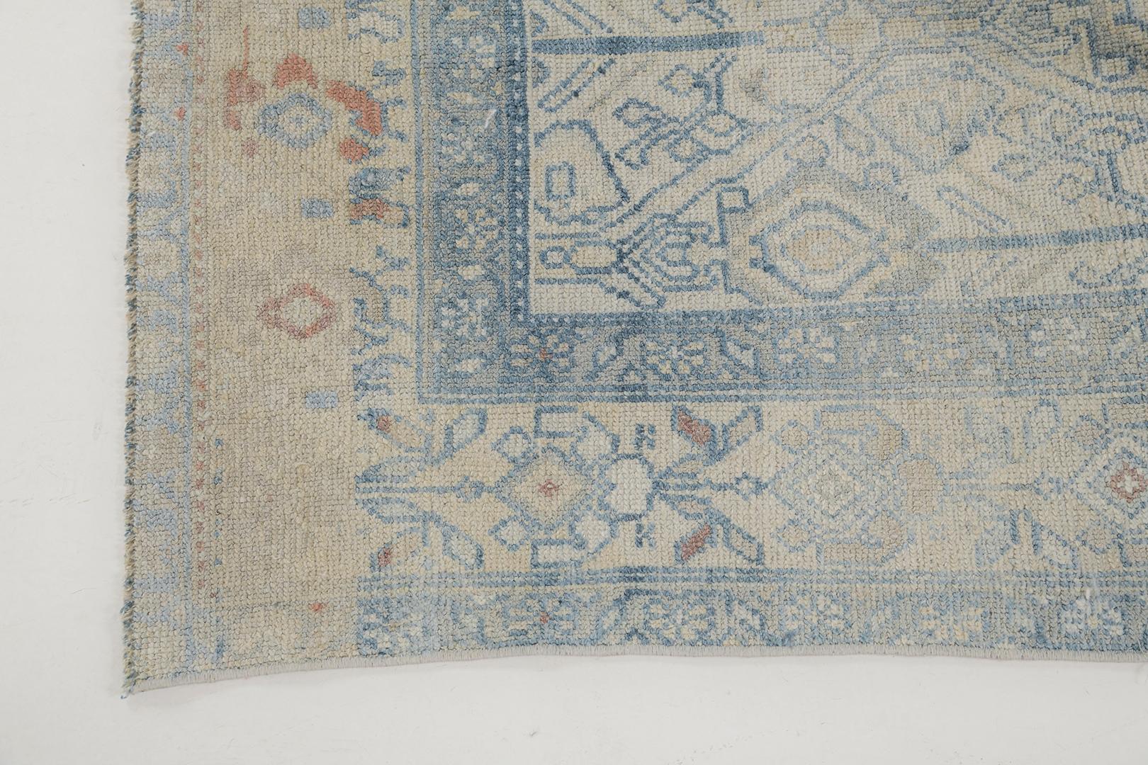 A captivating antique Persian Sarab featuring the most sought after muted tones of sapphire blue and sand. A myriad of blooming lotuses enclosed in panel style are spread gracefully allover the abrashed field. Enclosed with inner and outer floral