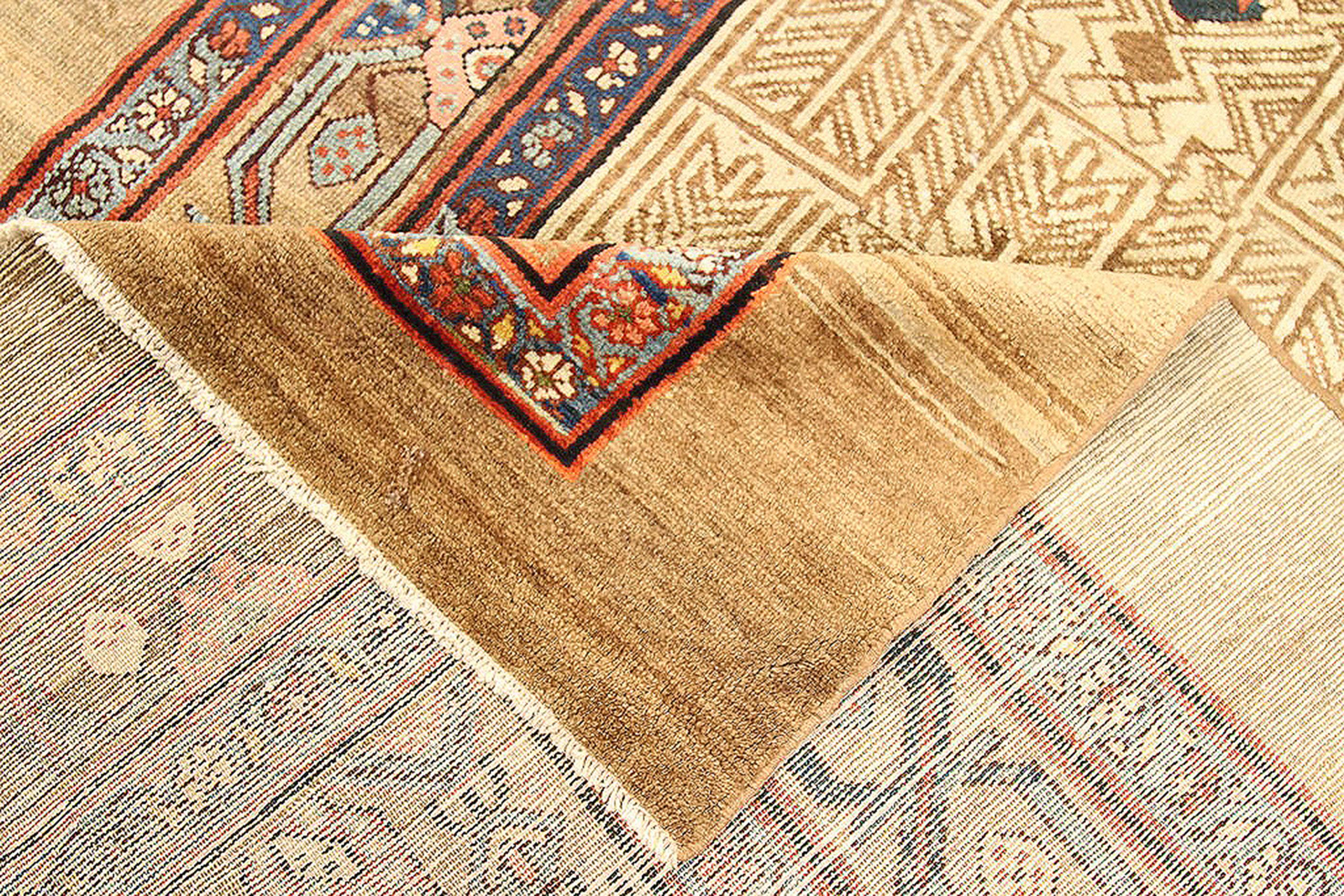 Antique Persian runner rug handwoven from the finest sheep’s wool and colored with all-natural vegetable dyes that are safe for humans and pets. It’s a traditional Sarab design featuring geometric details in beige and brown with blue and red floral