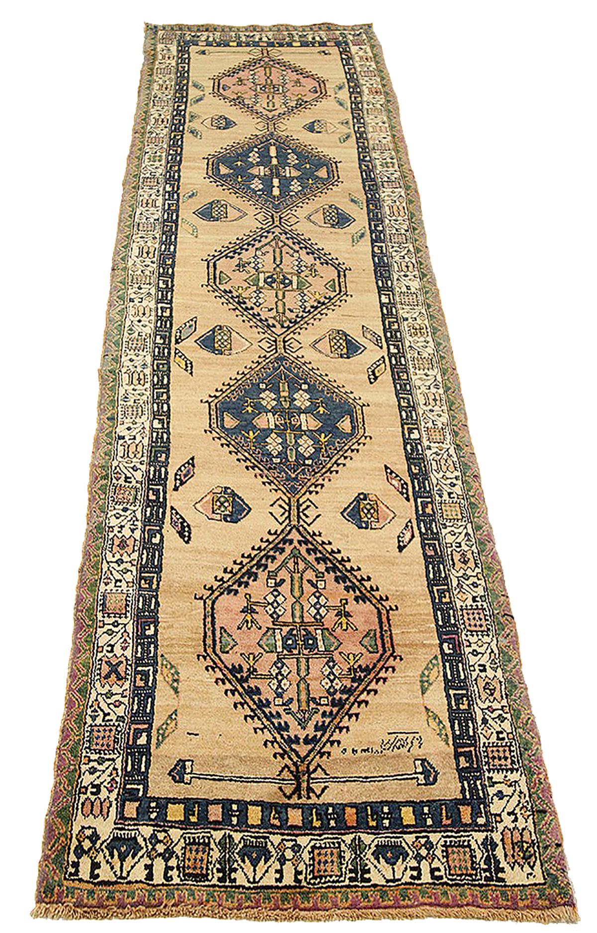 Antique Persian runner rug handwoven from the finest sheep’s wool and colored with all-natural vegetable dyes that are safe for humans and pets. It’s a traditional Sarab design featuring medallions in navy and pink with green and ivory floral