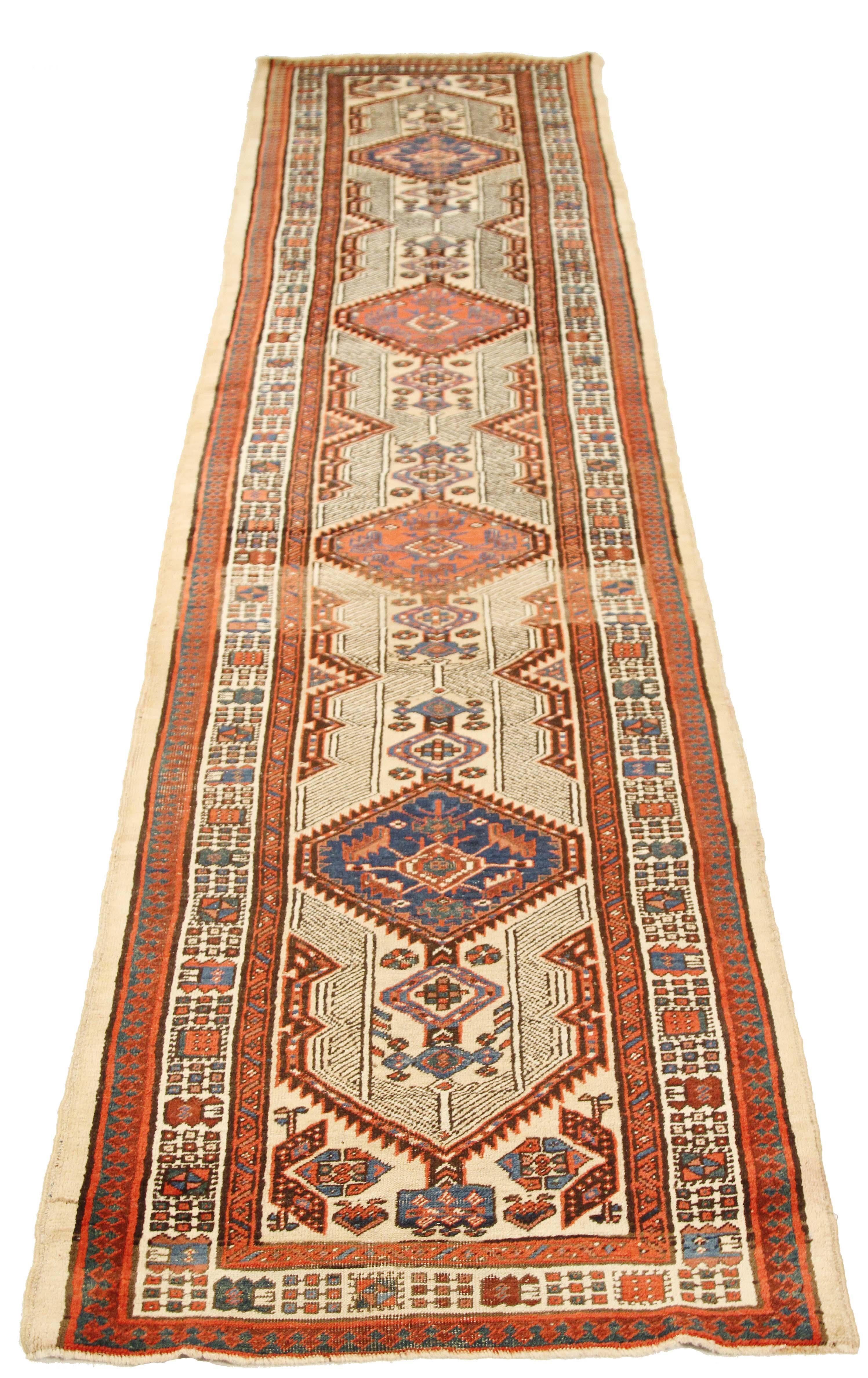 Antique Persian runner rug handwoven from the finest sheep’s wool and colored with all-natural vegetable dyes that are safe for humans and pets. It’s a traditional Sarab design featuring geometric details in black, beige and brown over an ivory