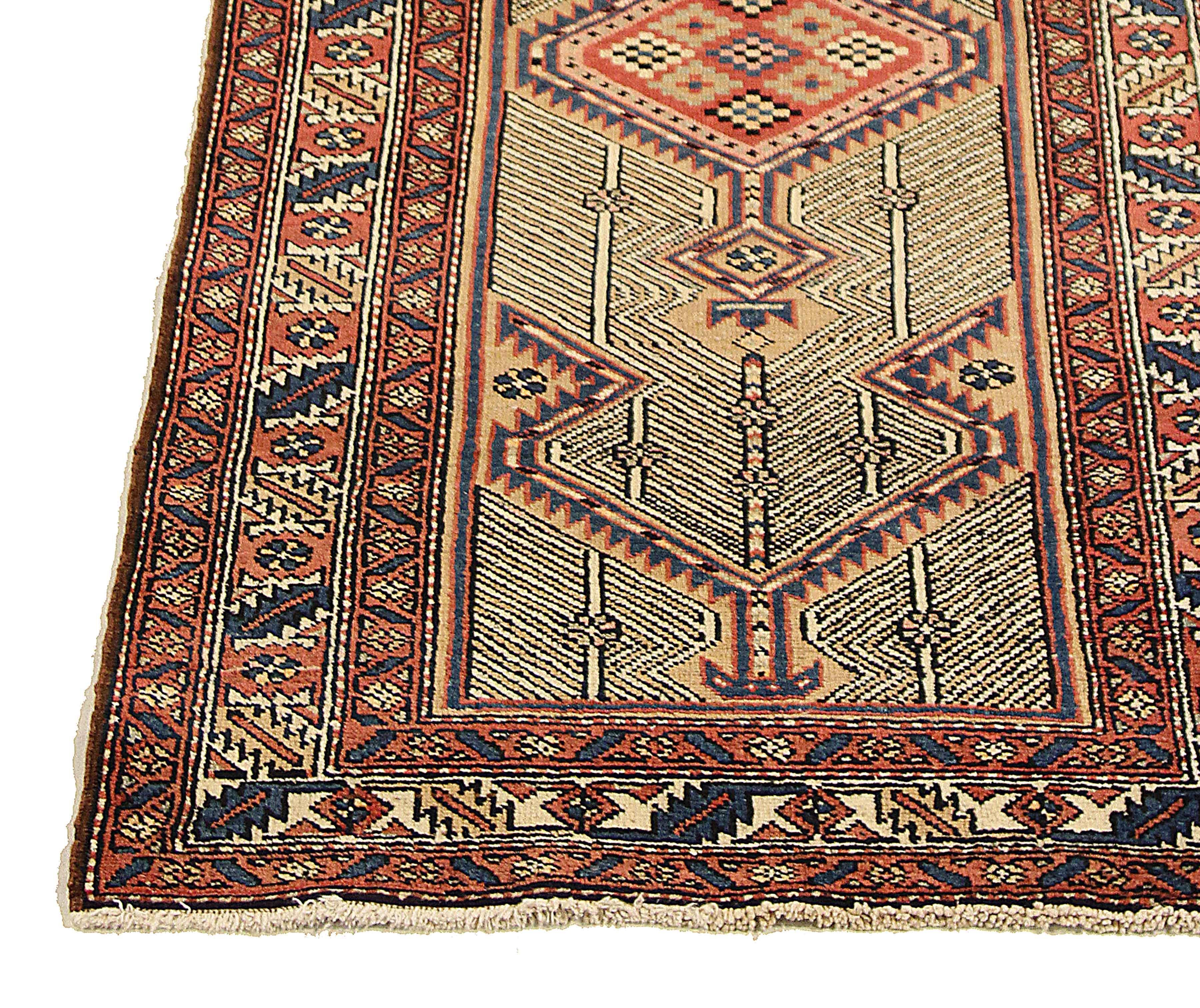 Antique Persian runner rug handwoven from the finest sheep’s wool and colored with all-natural vegetable dyes that are safe for humans and pets. It’s a traditional Sarab design featuring geometric details in blue and red over a mixed beige and red