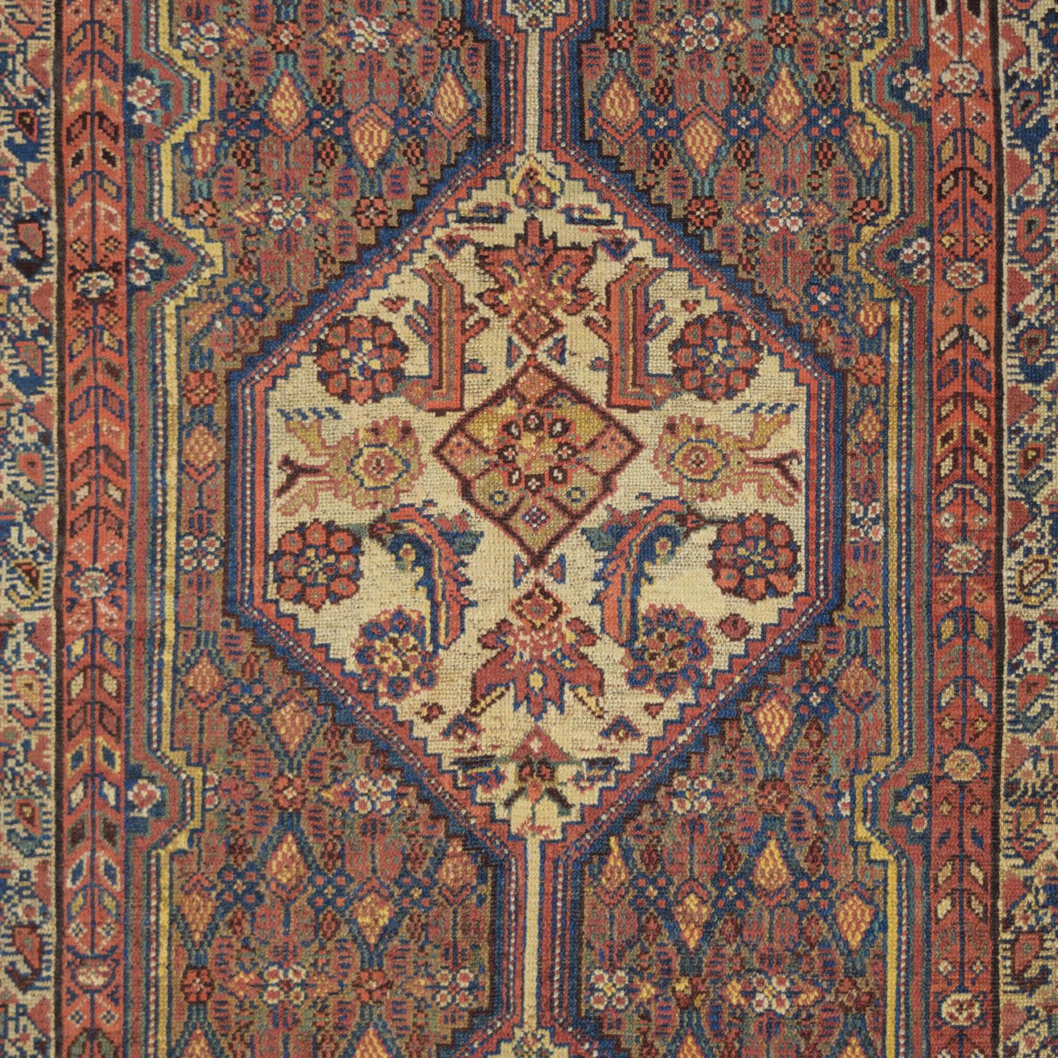 Crafted over 100 years ago in Iran, this antique Persian Saraband carpet is hand-knotted and measures 4’5” x 6’11”. This piece introduces patterns and tones strongly associated with Saraband carpets yet is woven using a Hamadan weave. The blue,