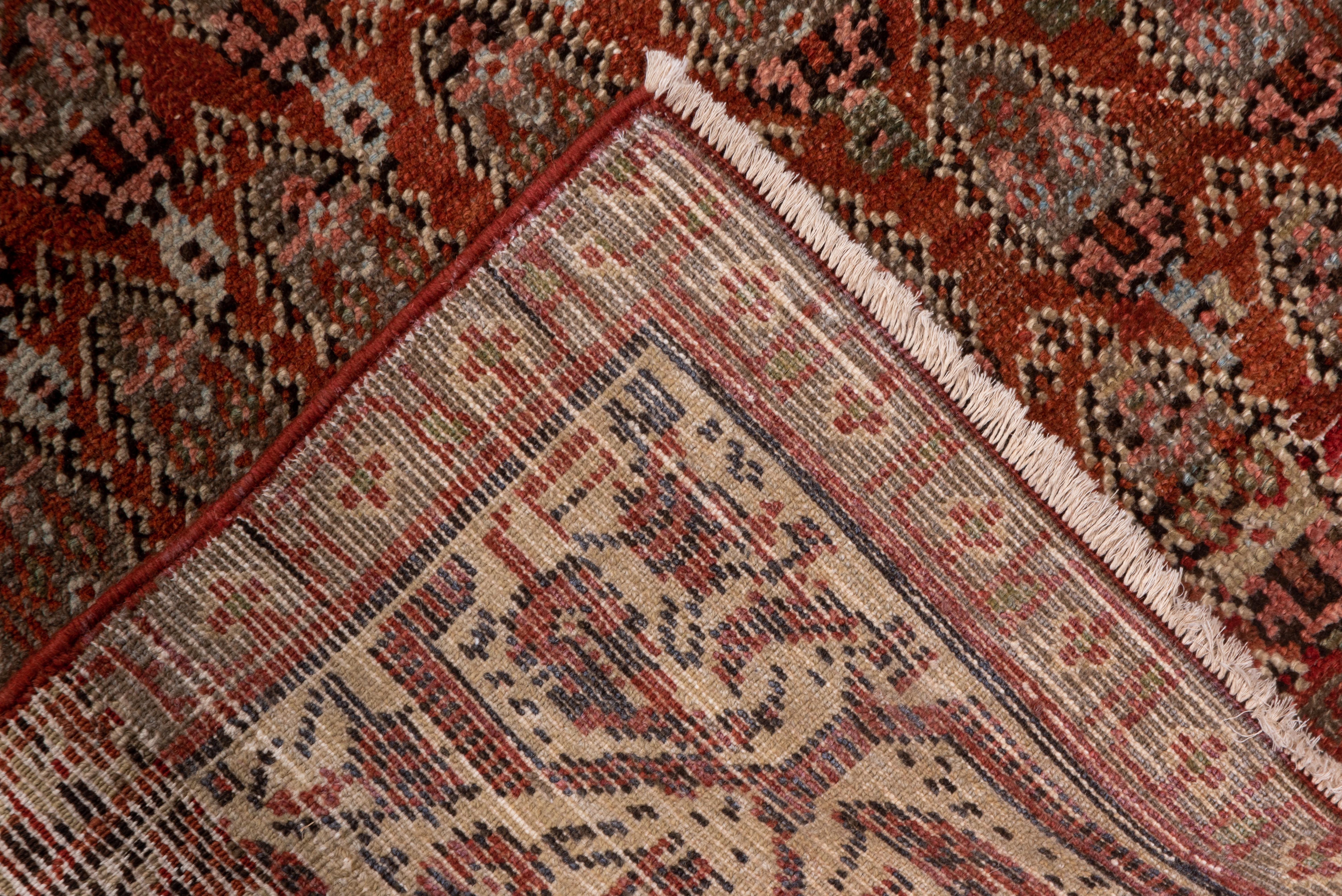 Urban-style runner with a red field expressing a half-drop, offset, row reversing, floriated boteh pattern. Dynamic taupe border with a faceted meander and suspended botehs. Medium weave, cotton foundation. Good condition. Iconic rendition. A
