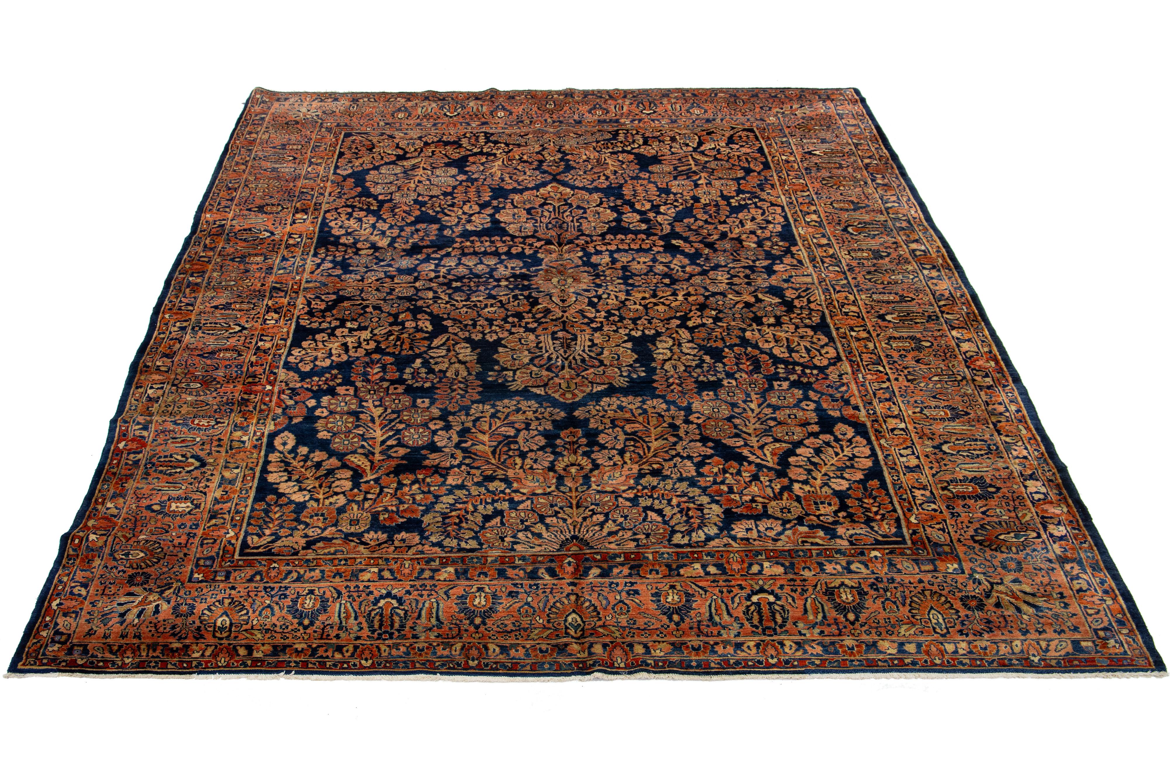  This is a beautiful hand-knotted wool Sarouk Farahan rug with a navy blue field. The rug features a rust colored frame with peach and tan accents in a classic floral design. 

This rug measures 8'9
